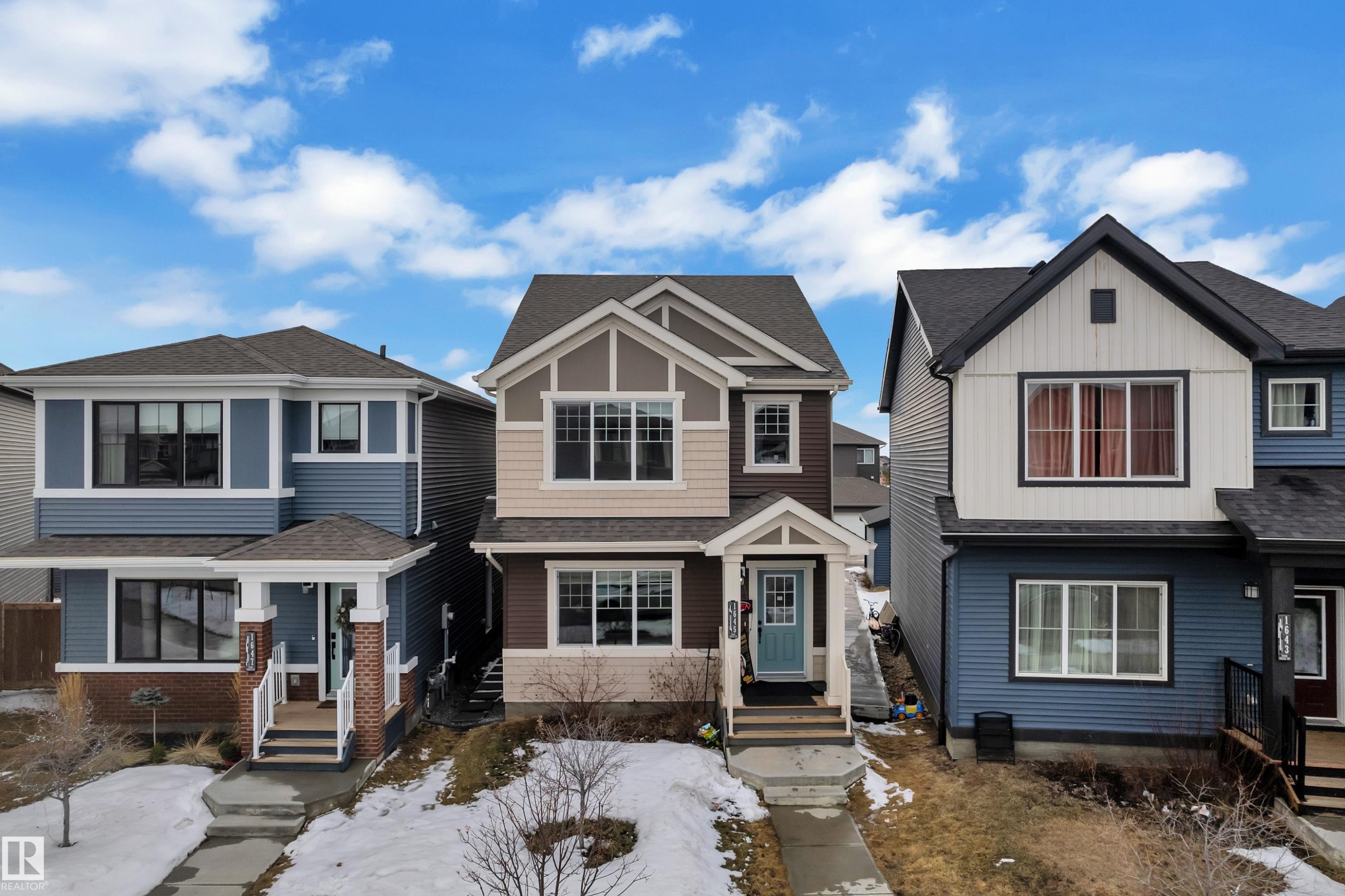 Two-story residence featuring a multi-tone exterior with a light blue front door and white trim - 1645 Plum Circle Circle Sw, Edmonton, AB - Outdoor With Facade