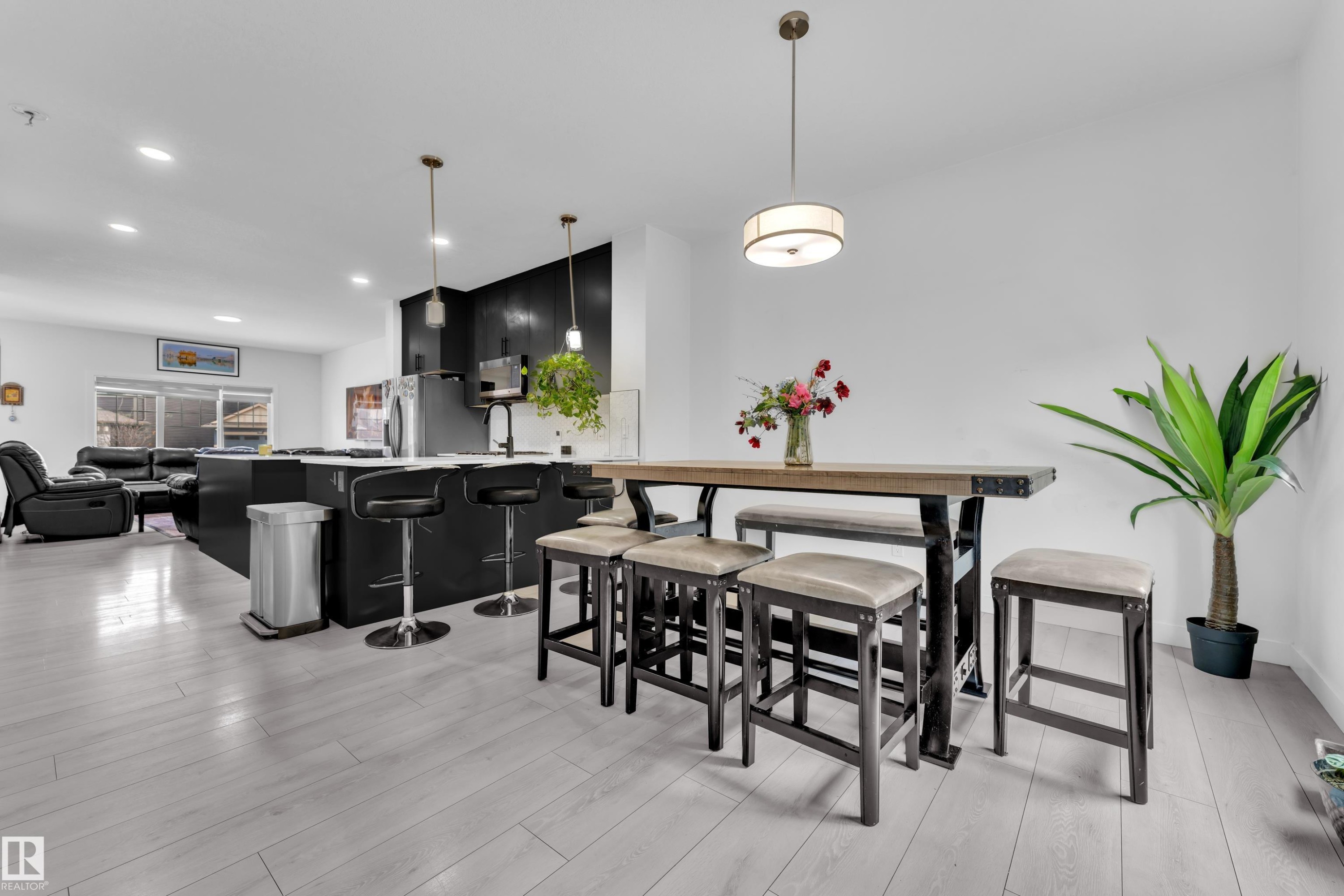 Open-concept kitchen and dining area featuring light wood-finish flooring, recessed lighting, and a modern kitchen island with pendant lighting - 1645 Plum Circle Circle Sw, Edmonton, AB - Indoor Photo Showing Dining Room