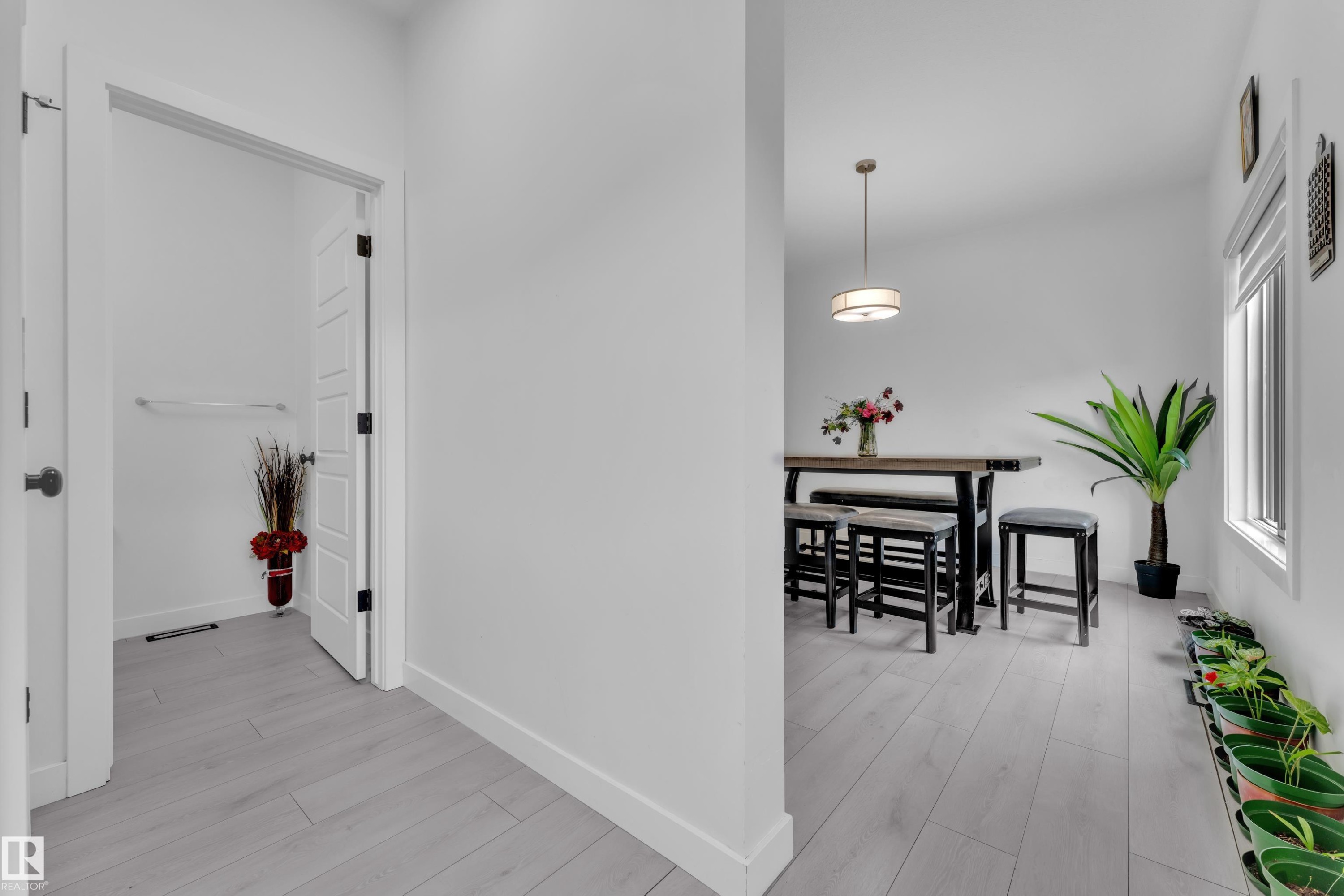 Light wood-finish flooring extending into an adjacent room - 1645 Plum Circle Circle Sw, Edmonton, AB - Indoor Photo Showing Other Room