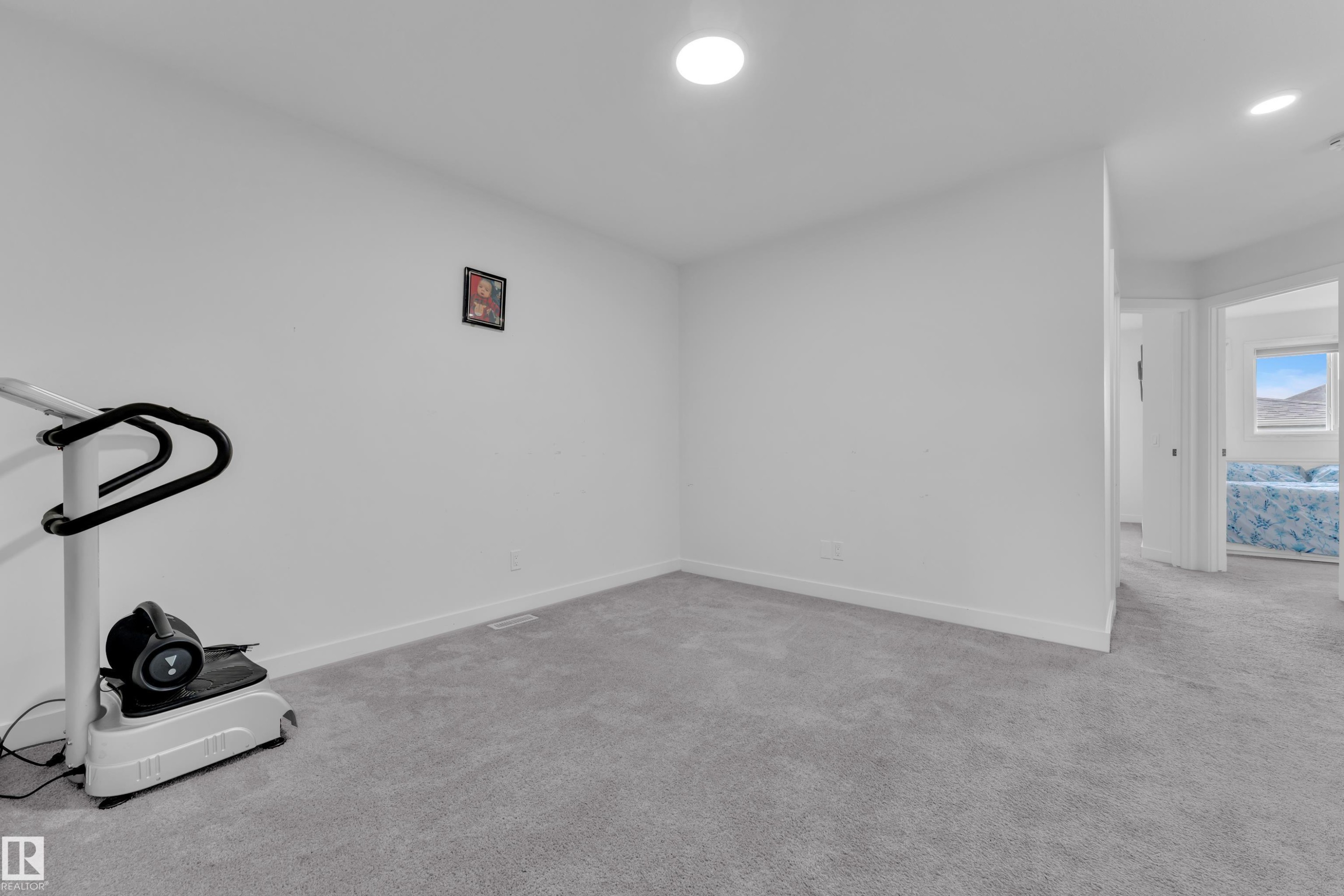 Carpeted room with white walls and recessed ceiling lighting - 1645 Plum Circle Circle Sw, Edmonton, AB - Indoor Photo Showing Other Room