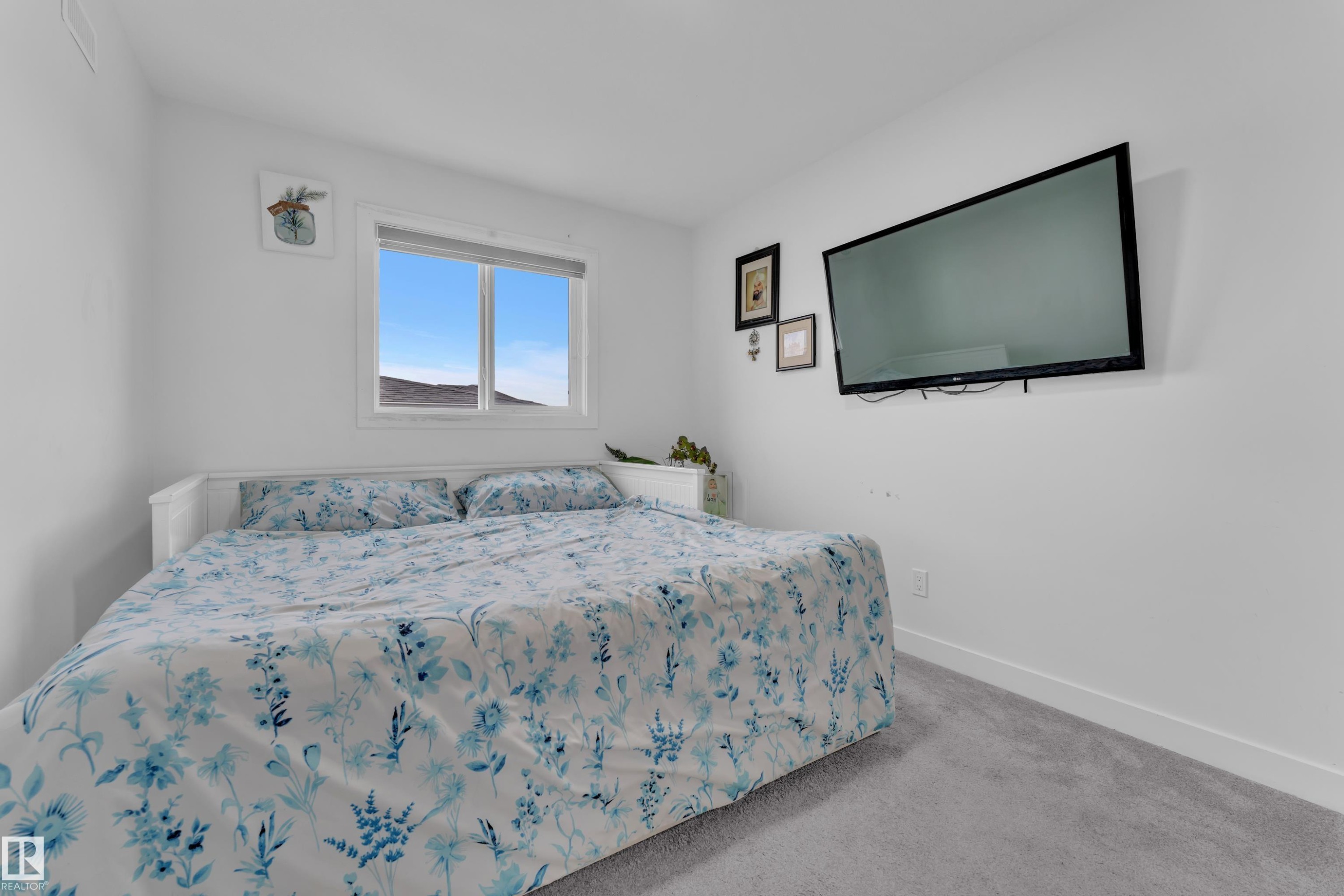 Bedroom featuring a window with a white frame, light gray carpeting, and white walls with baseboards - 1645 Plum Circle Circle Sw, Edmonton, AB - Indoor Photo Showing Bedroom