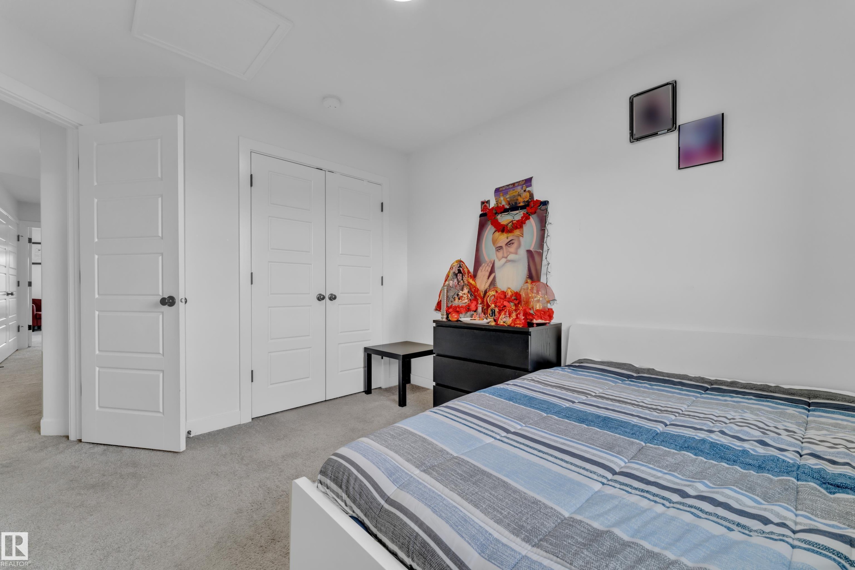 Carpeted interior room featuring white walls and a white five-panel interior door - 1645 Plum Circle Circle Sw, Edmonton, AB - Indoor Photo Showing Bedroom