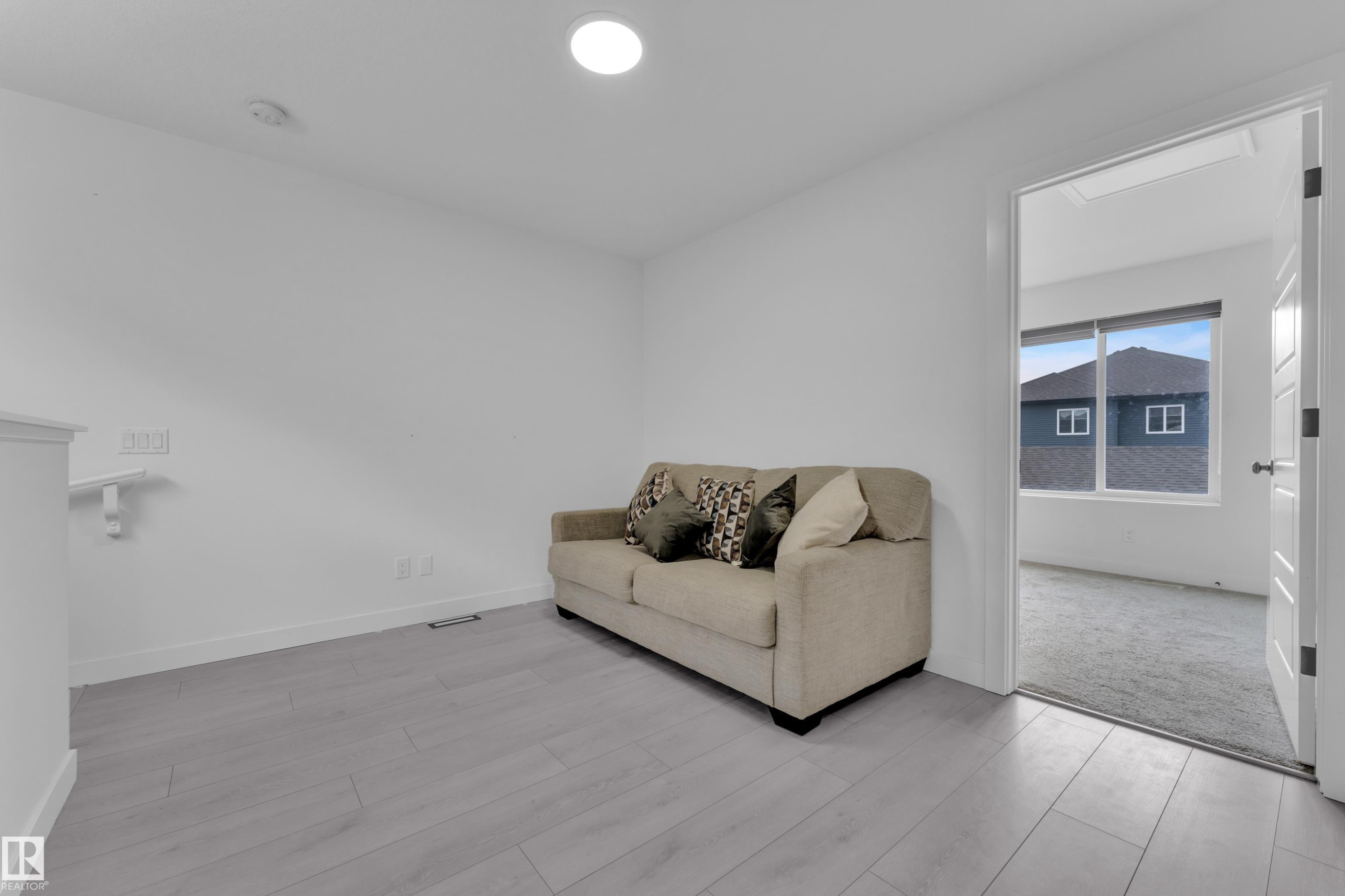 Light wood-finish flooring complements the neutral wall color - 1645 Plum Circle Circle Sw, Edmonton, AB - Indoor