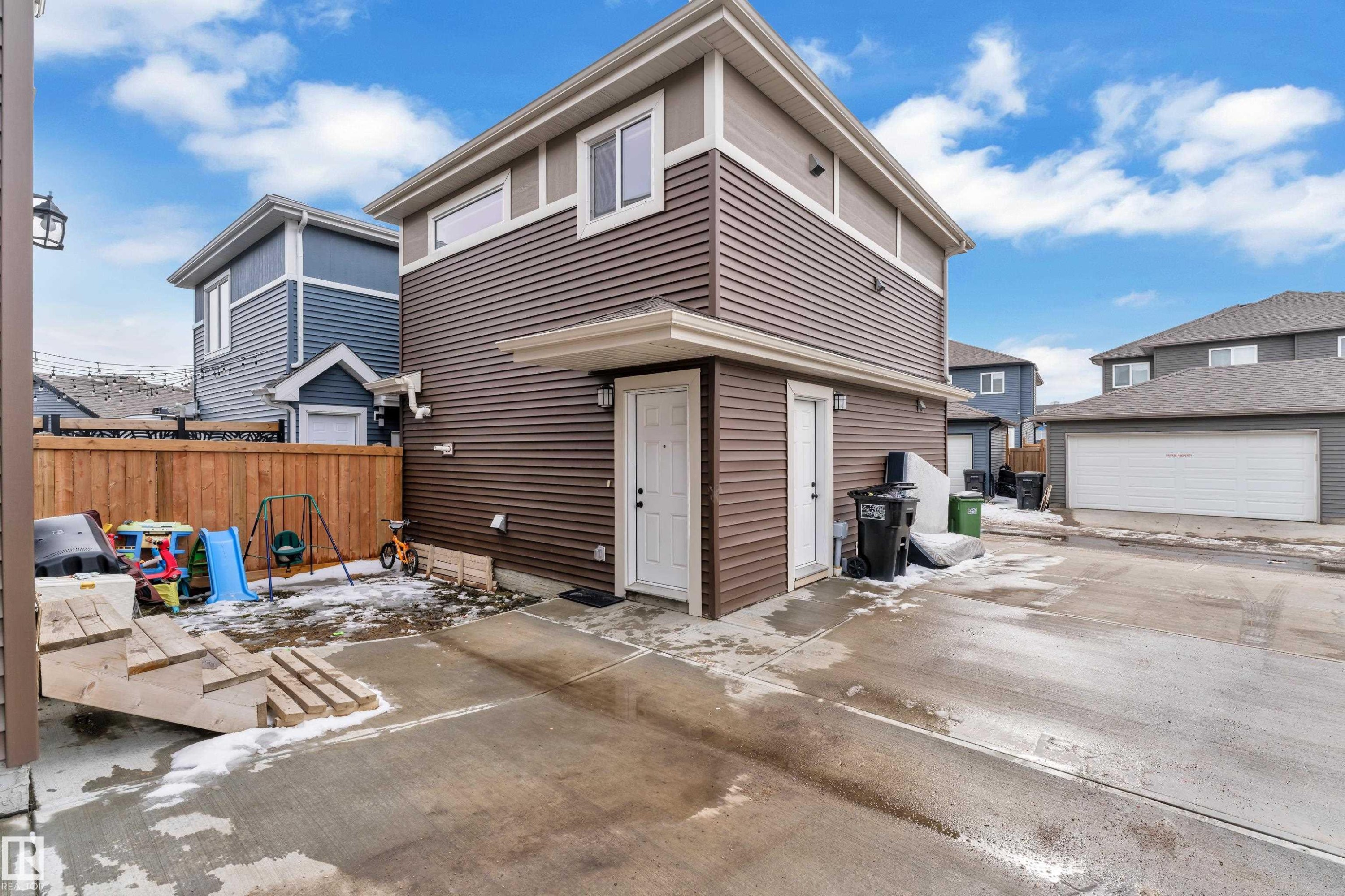 Contemporary brown siding exterior with white trim and a contrasting light gray soffit - 1645 Plum Circle Circle Sw, Edmonton, AB - Outdoor
