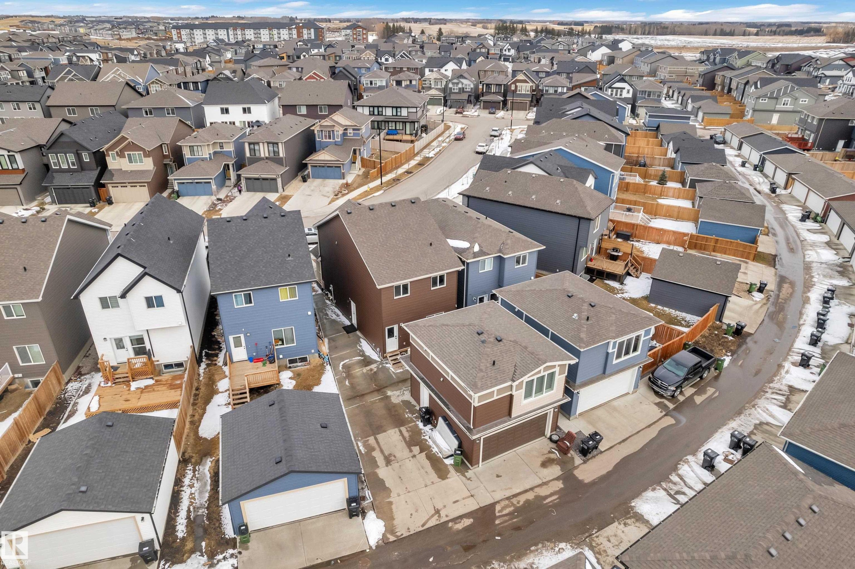 Residential community featuring diverse home exteriors and attached garages - 1645 Plum Circle Circle Sw, Edmonton, AB - Outdoor With View