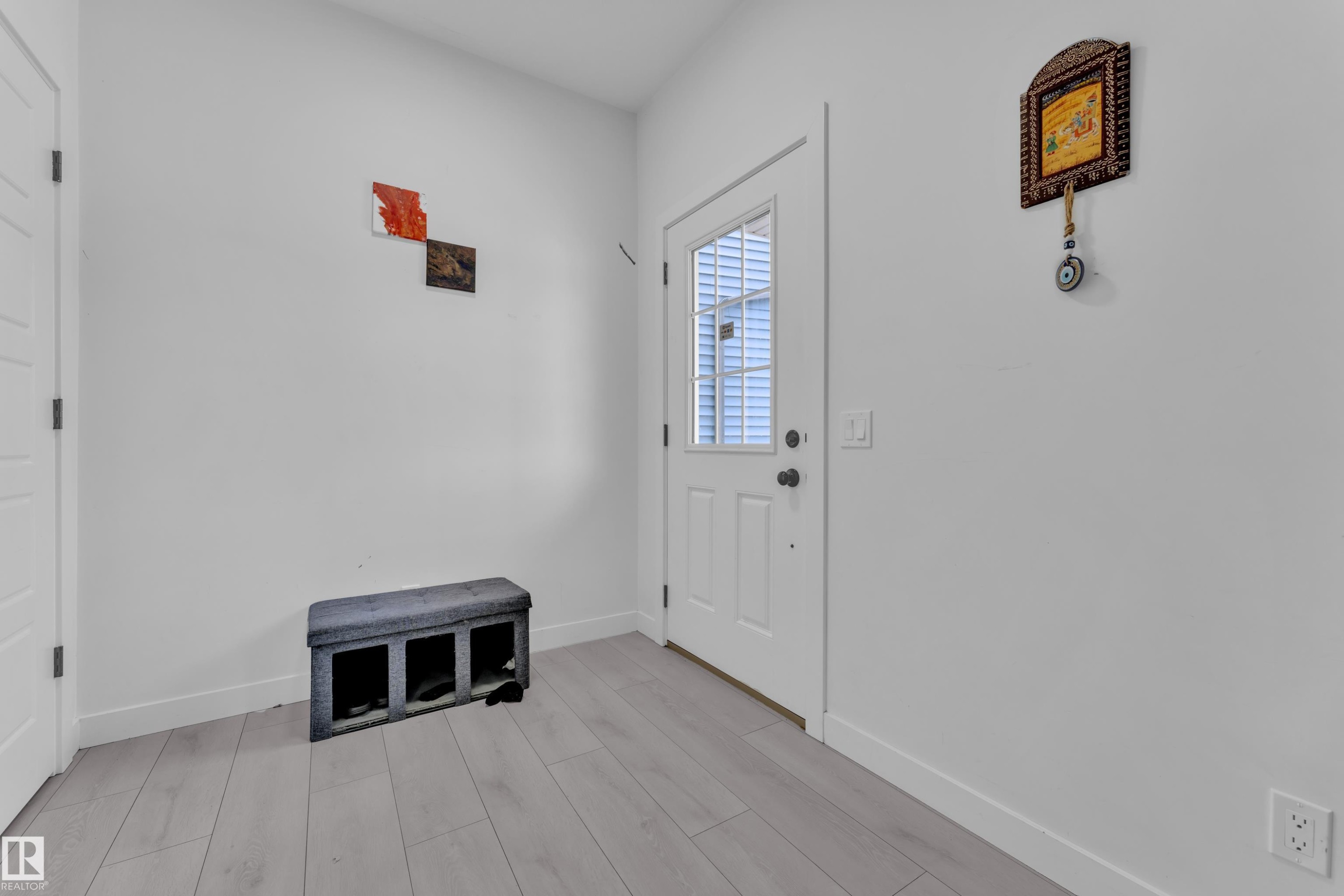 Entryway featuring light wood-finish flooring and a white paneled door with an integrated window - 1645 Plum Circle Circle Sw, Edmonton, AB - Indoor Photo Showing Other Room