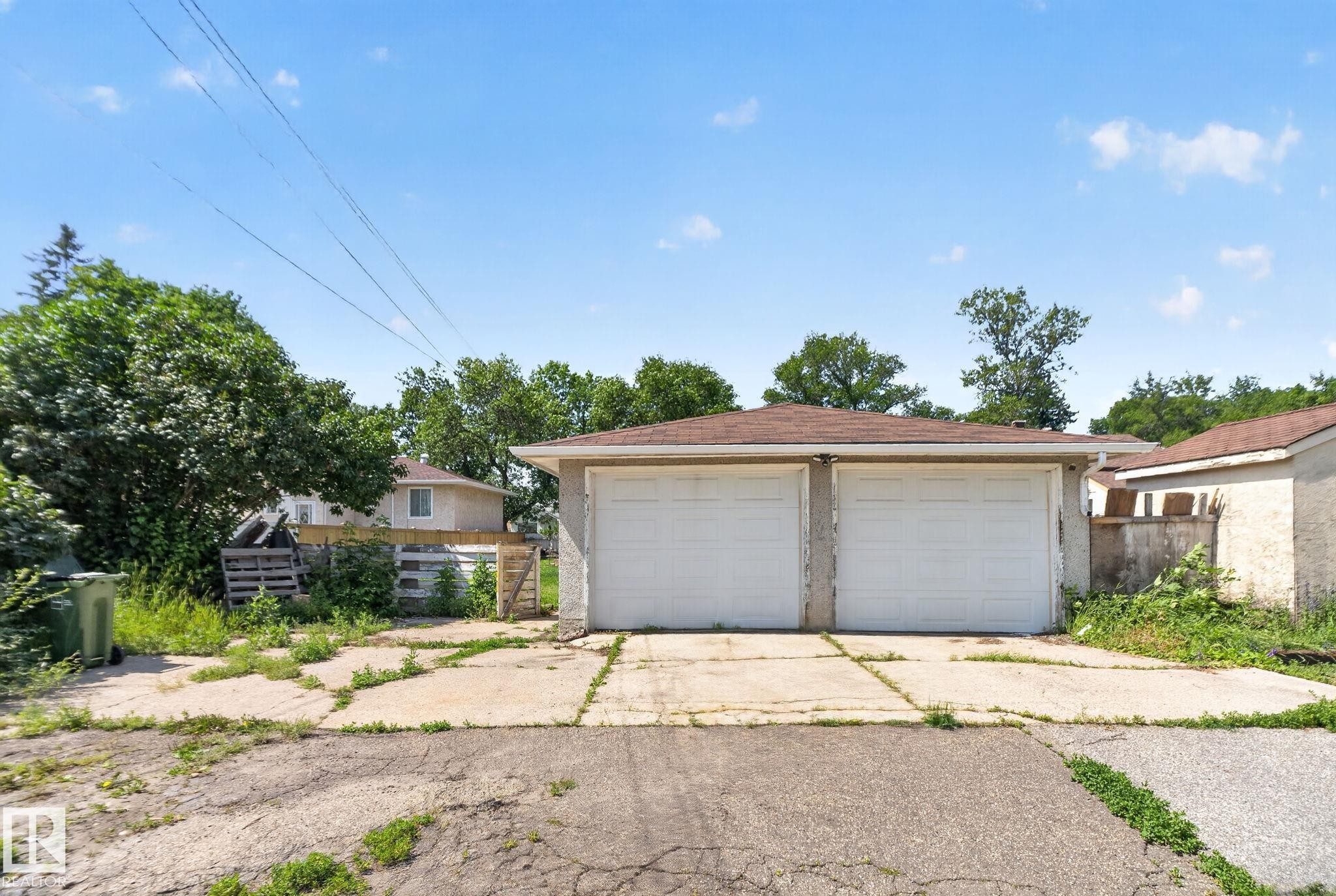 Two-car detached garage with white overhead doors and a shingled roof - 12229 88 Street Nw, Edmonton, AB