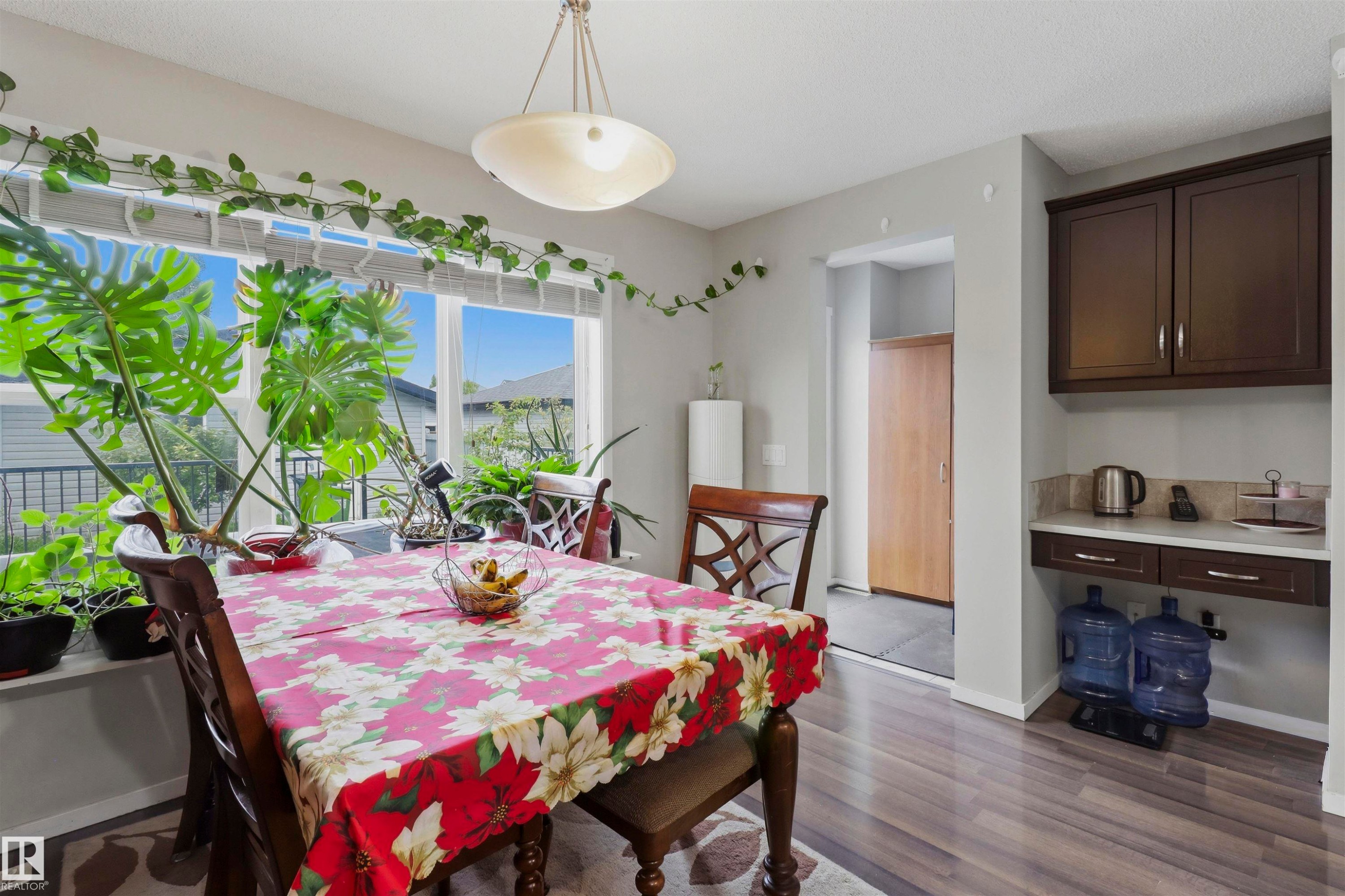 Dining area with wood-finish flooring and a built-in serving station featuring dark wood cabinetry and a light-colored countertop - 1528 35 Avenue Nw, Edmonton, AB - Indoor Photo Showing Dining Room