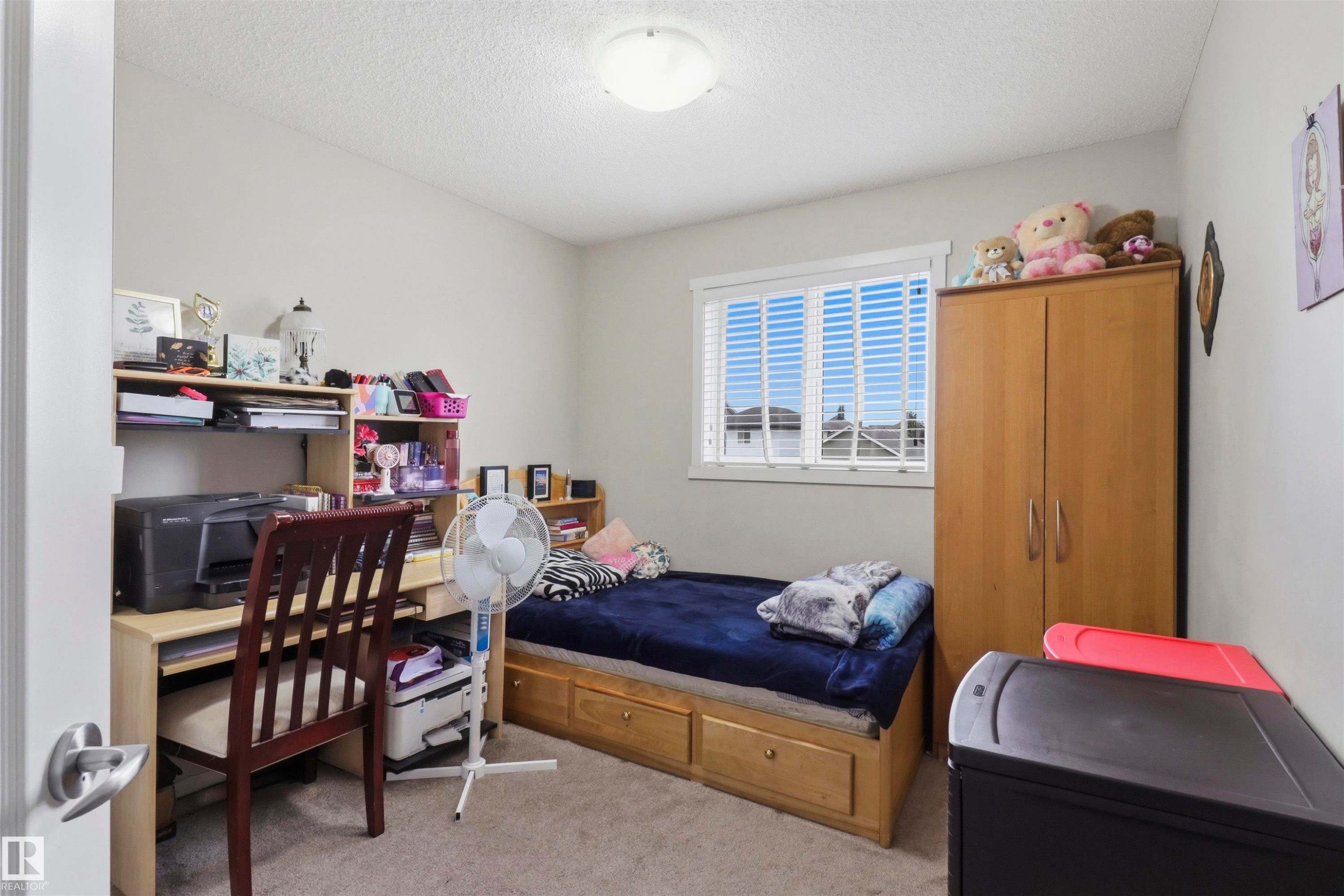 Carpeted room with a ceiling-mounted light fixture, a window featuring white blinds, and light-toned wall paint - 1528 35 Avenue Nw, Edmonton, AB - Indoor Photo Showing Bedroom