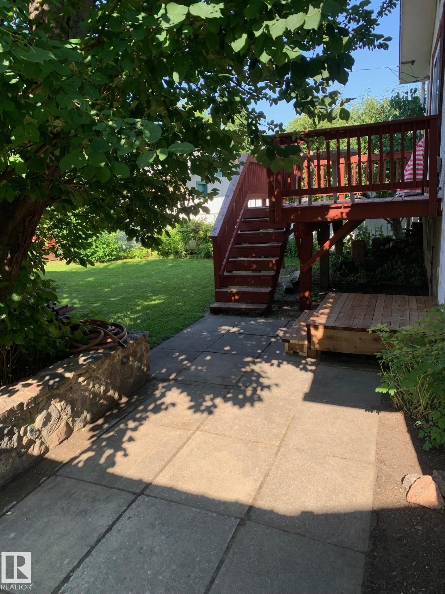 Elevated wooden deck with stairs leading to a ground-level patio - 16321 - 109A Ave Nw, Edmonton, AB - Outdoor