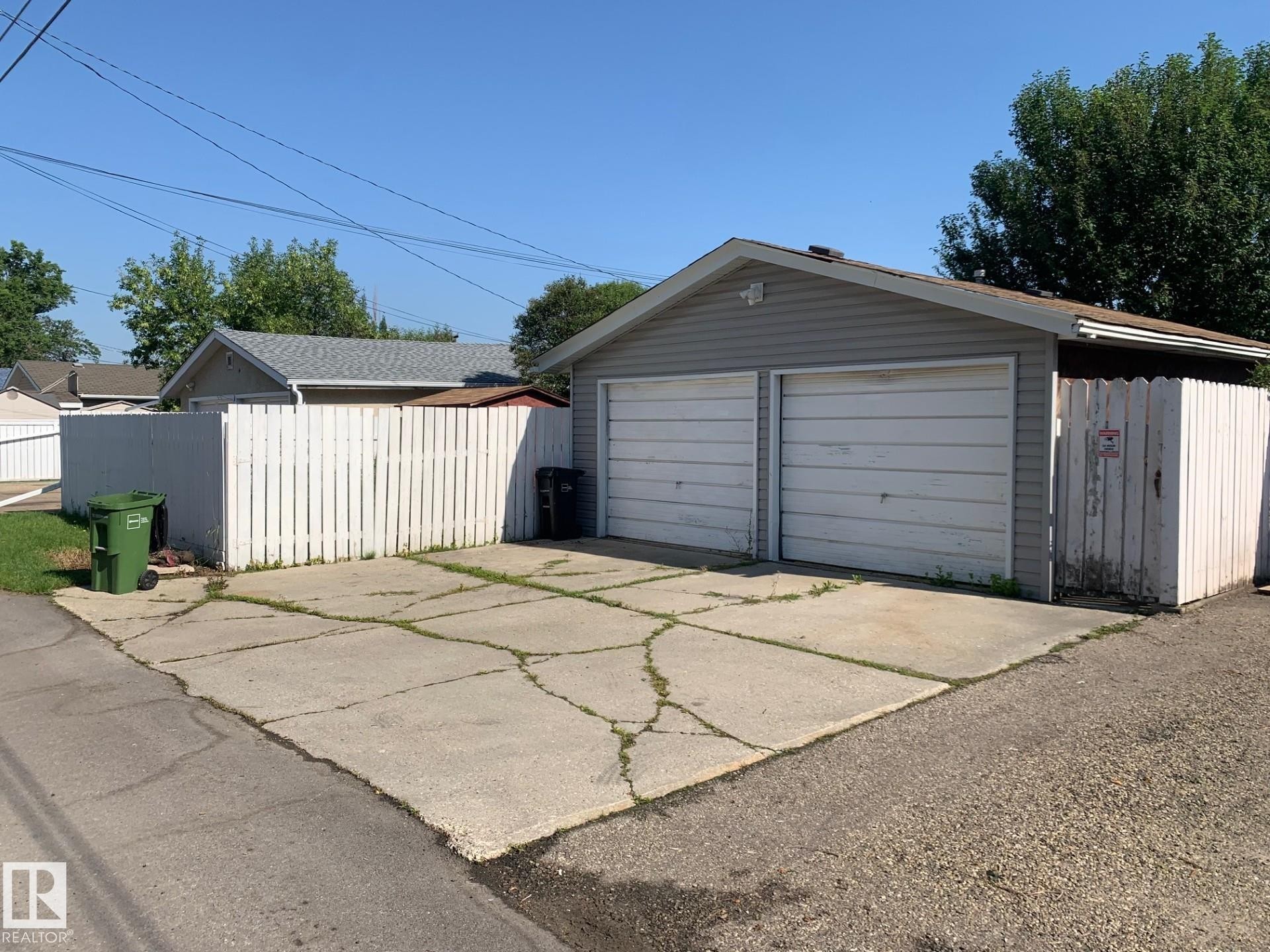 Two-car detached garage featuring horizontal siding and panel garage doors - 16321 - 109A Ave Nw, Edmonton, AB - Outdoor With Exterior