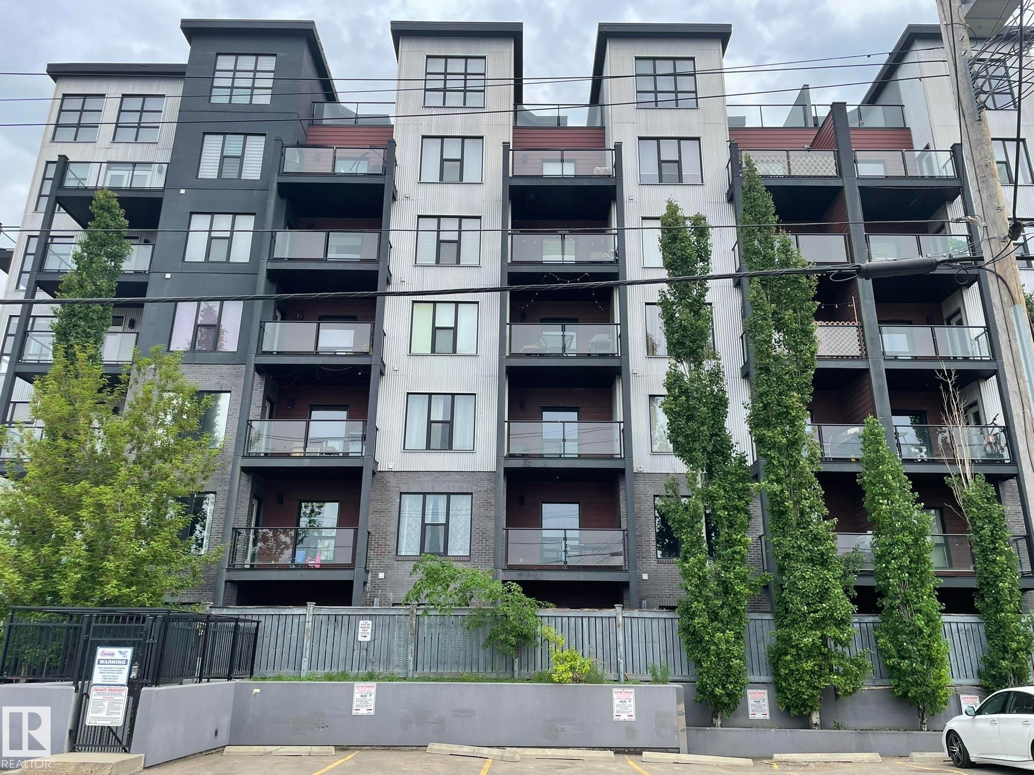 Multi-story building featuring modern architecture with contrasting dark and light gray facades - #504 10518 113 St Nw, Edmonton, AB - Outdoor With Balcony With Facade