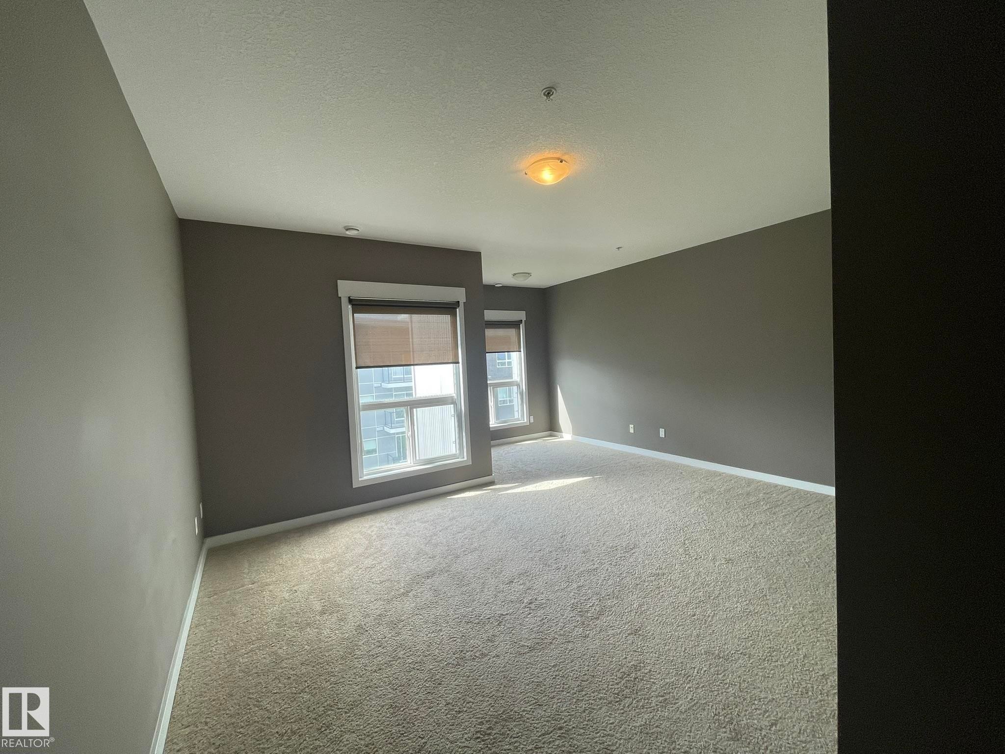 Carpeted room with multiple windows featuring blinds - #504 10518 113 St Nw, Edmonton, AB - Indoor Photo Showing Other Room