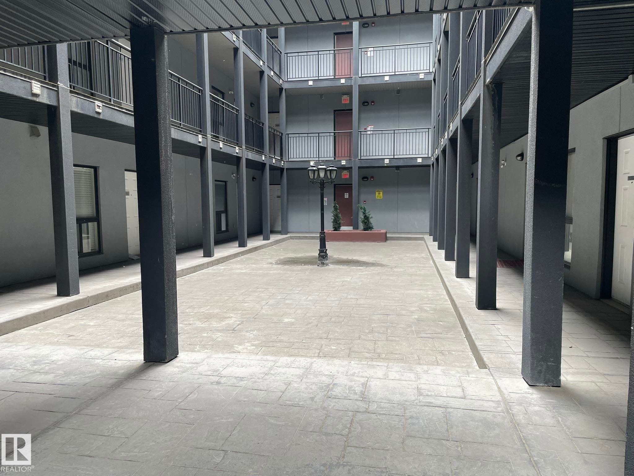 Central courtyard featuring stamped concrete paving and a decorative lamppost - #504 10518 113 St Nw, Edmonton, AB - Outdoor With Exterior