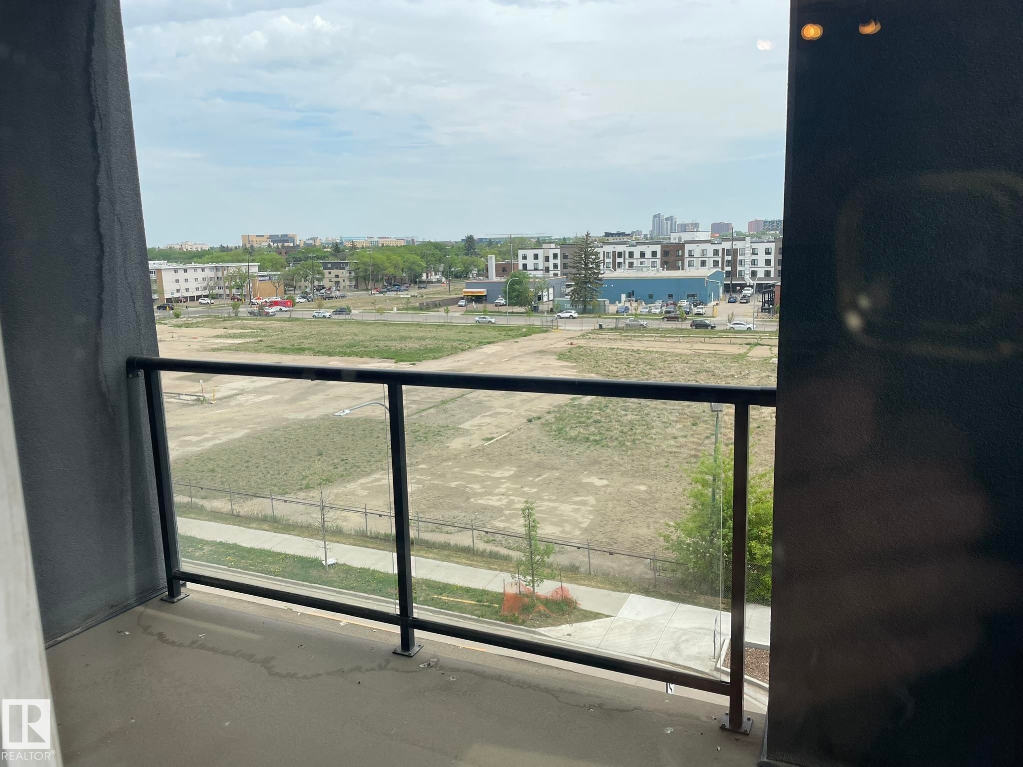 Balcony with clear glass railing, offering broad cityscape and open field panoramas - #504 10518 113 St Nw, Edmonton, AB - Outdoor With Balcony With View