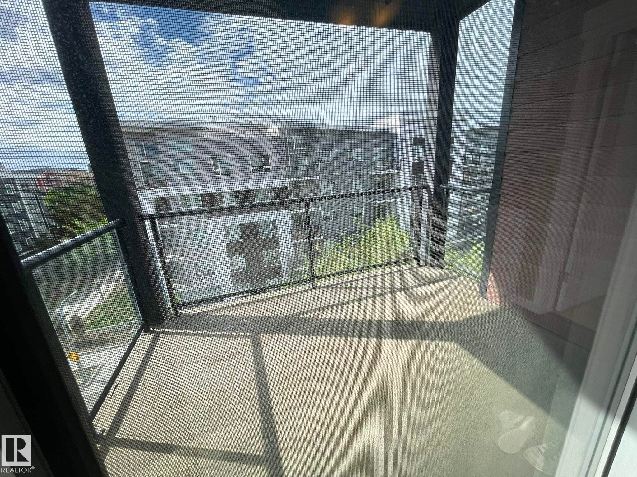 Outdoor balcony featuring a concrete floor and black metal railings with glass panels - #504 10518 113 St Nw, Edmonton, AB - Photo Showing Other Room