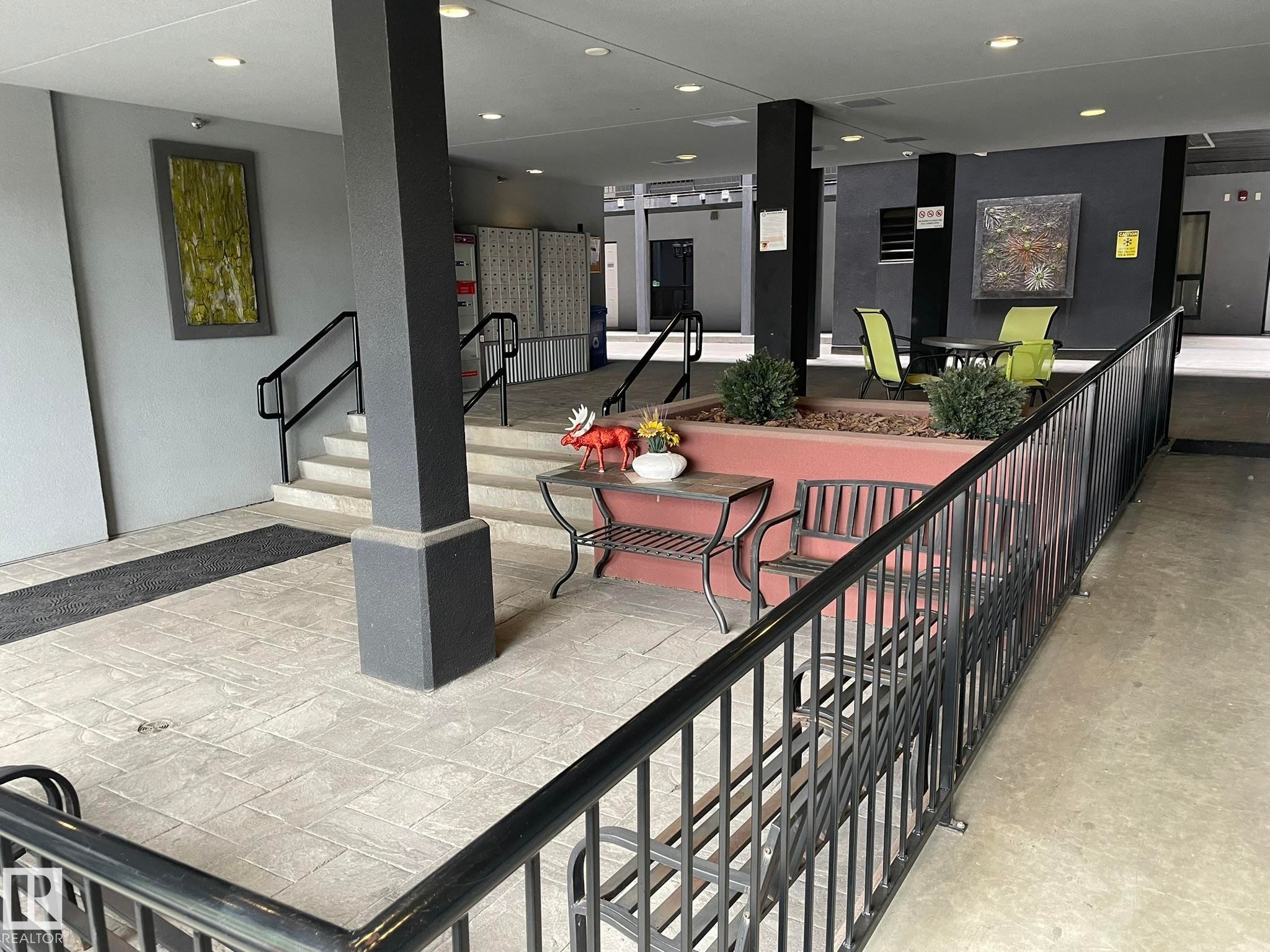 Covered entryway featuring textured concrete flooring, black metal railings, and integrated planters - #504 10518 113 St Nw, Edmonton, AB - Indoor Photo Showing Other Room