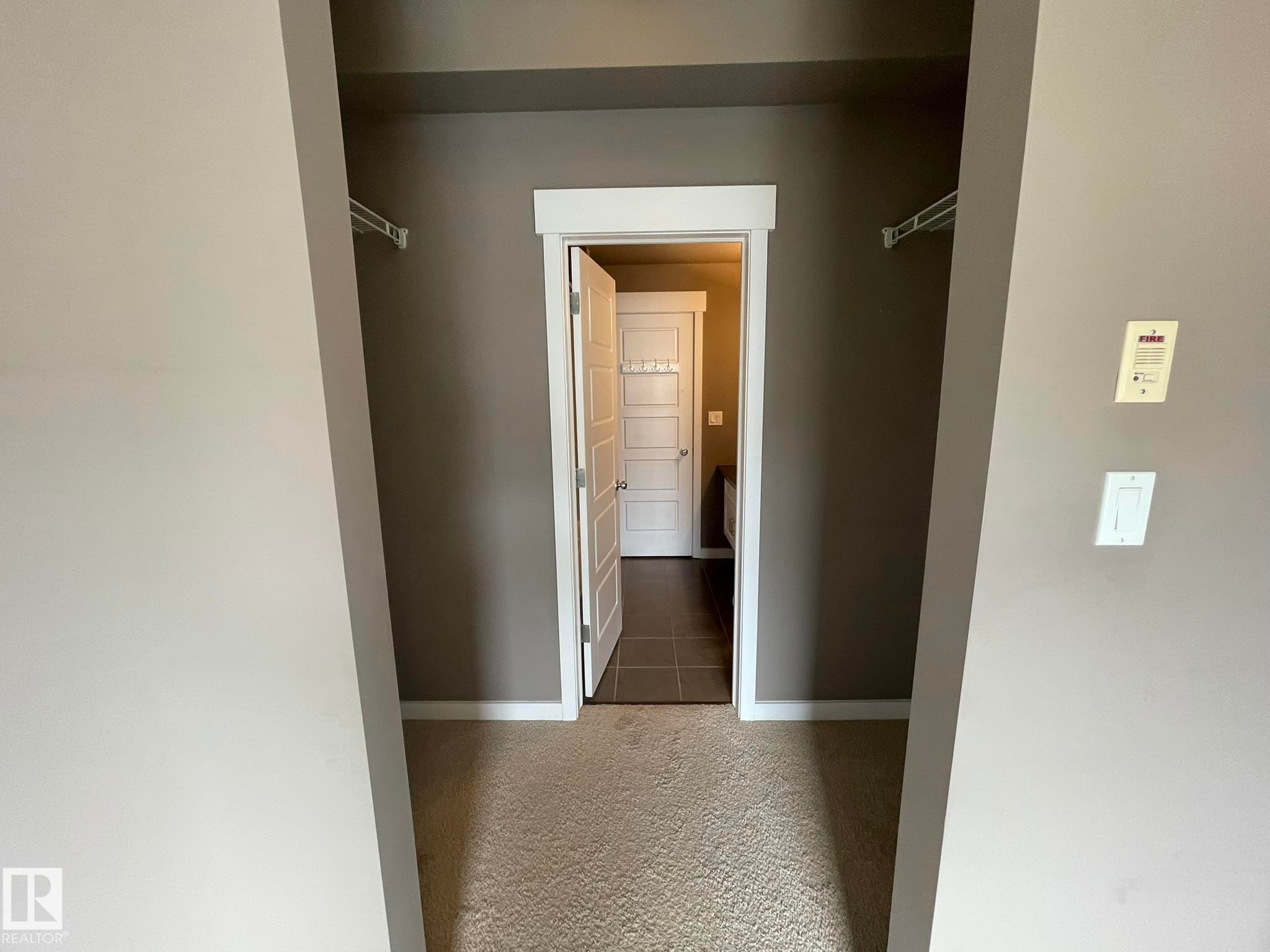Carpeted area featuring neutral wall tones and a doorway with white trim - #504 10518 113 St Nw, Edmonton, AB - Indoor Photo Showing Other Room