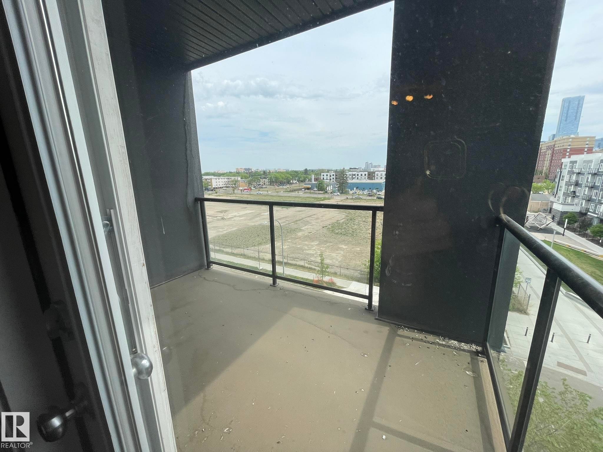 Private balcony with a concrete floor, glass and metal railings, and a wood-panel ceiling - #504 10518 113 St Nw, Edmonton, AB - Outdoor With Balcony