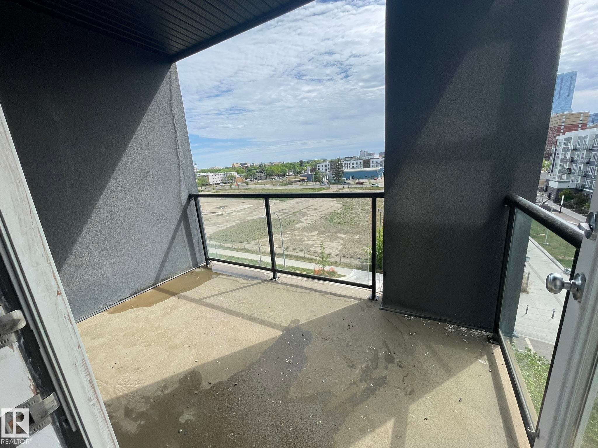 Private balcony with concrete flooring, framed by dark grey textured walls and a slatted ceiling - #504 10518 113 St Nw, Edmonton, AB - Outdoor With Balcony