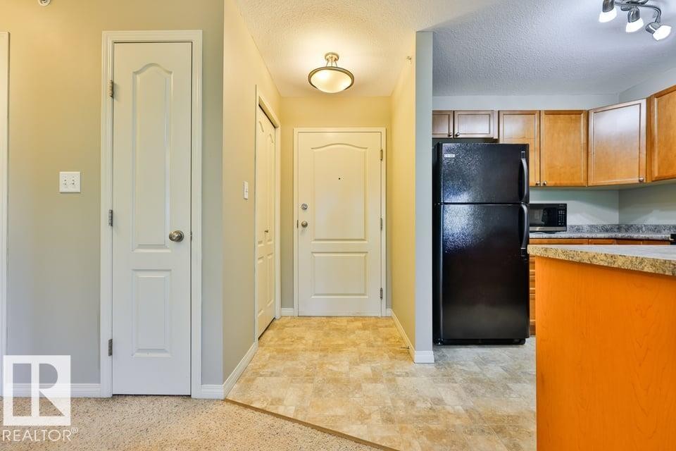 Entryway with neutral wall paint and a flush-mount light fixture - #406 4903 47 Av, Stony Plain, AB - Indoor Photo Showing Kitchen