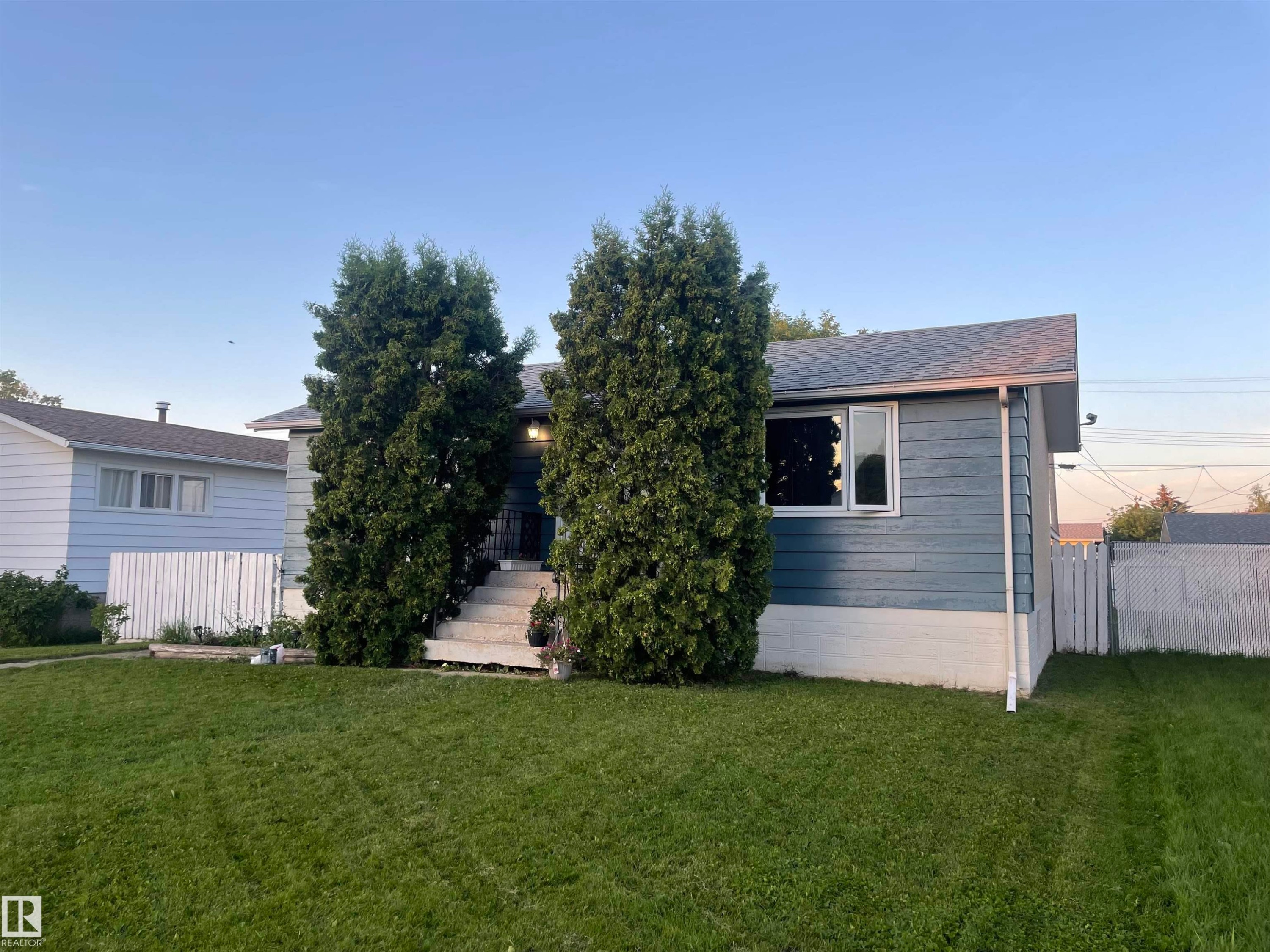 Blue horizontal siding with white trim and a contrasting white foundation - 4823 49 Street, Clyde, AB - Outdoor