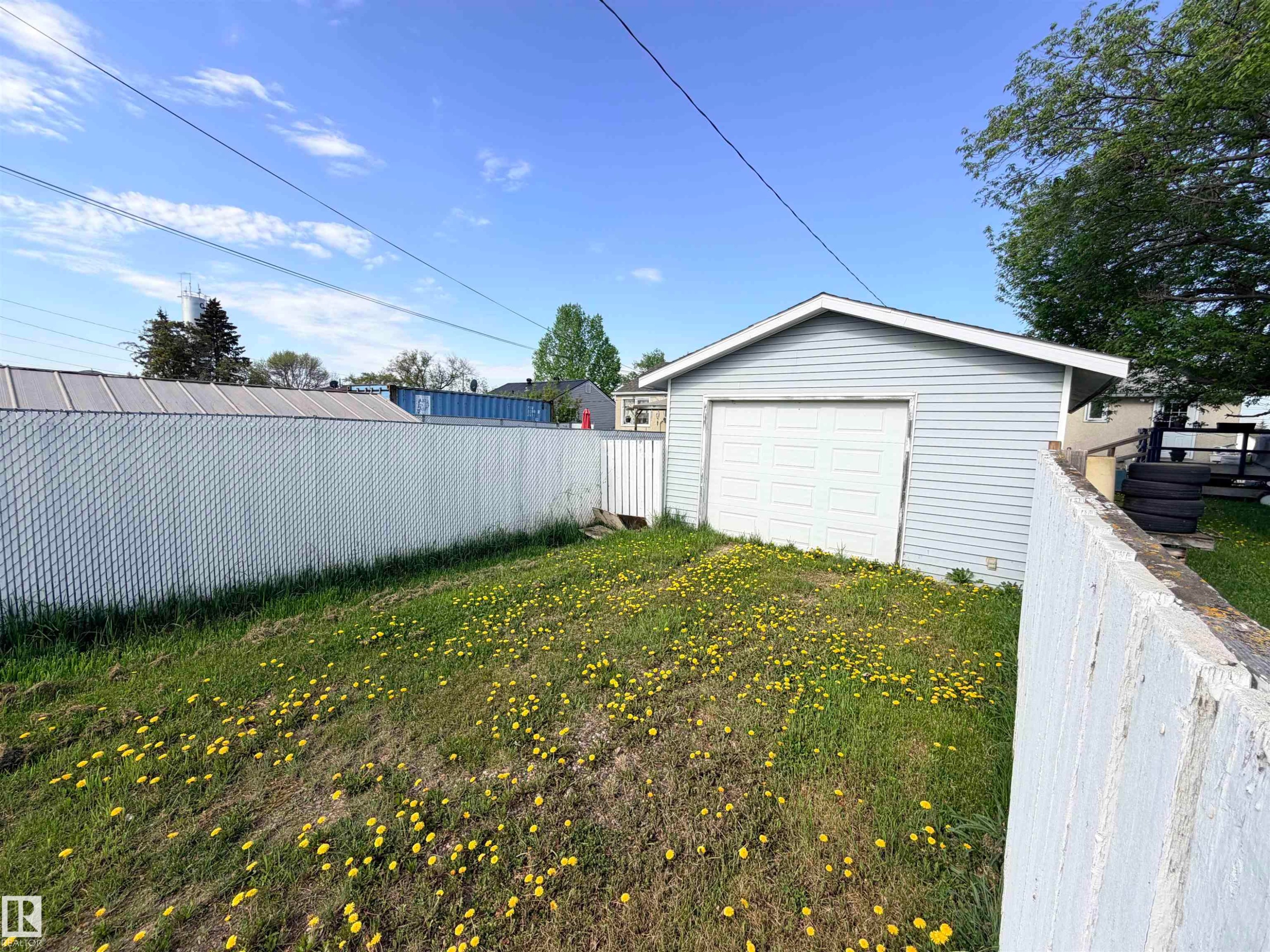 Detached garage with light blue siding and a white paneled door - 4823 49 Street, Clyde, AB - Outdoor