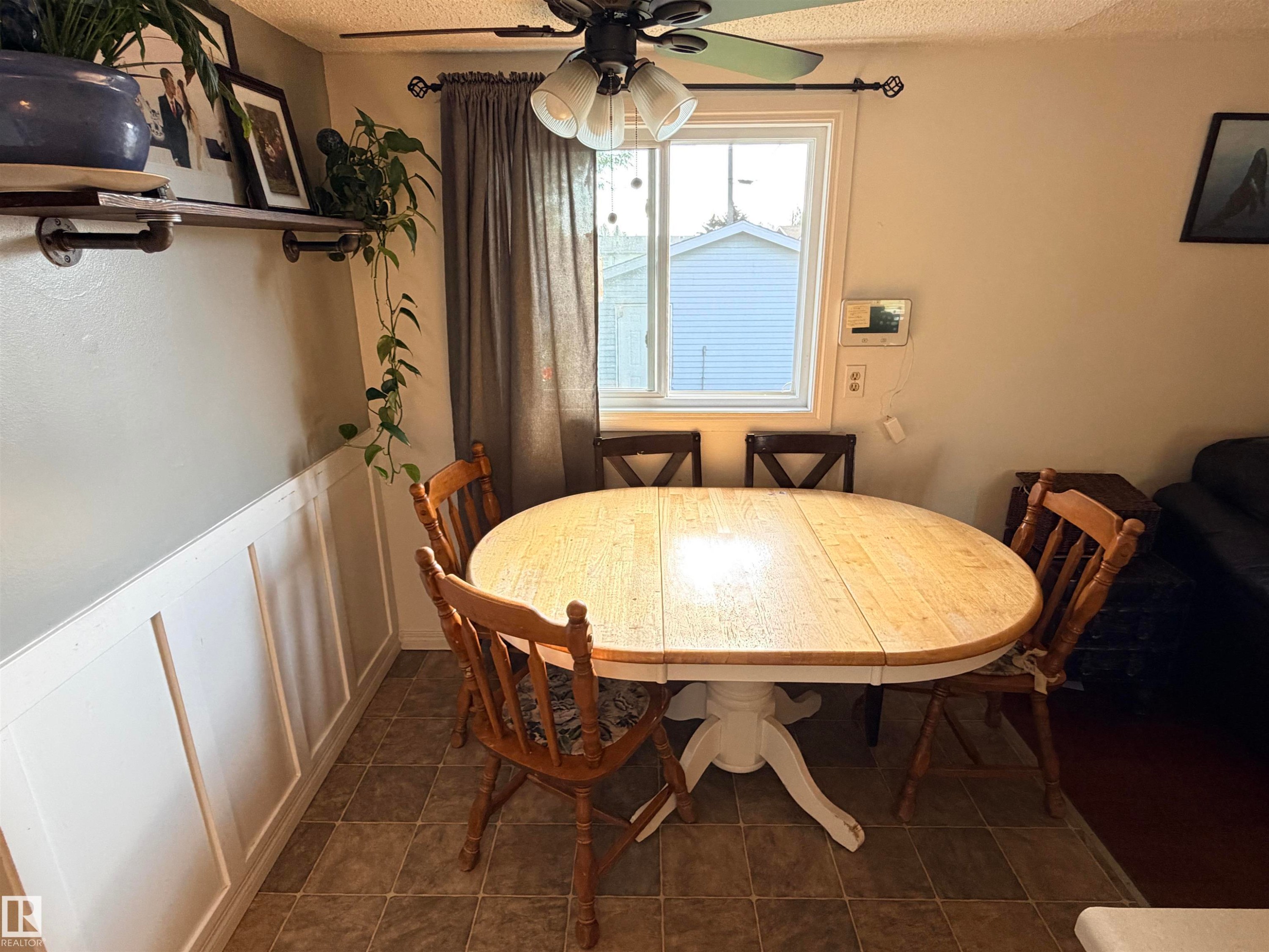 Dining area featuring wainscoting, wood-finish flooring, and a window with blinds - 4823 49 Street, Clyde, AB - Indoor Photo Showing Dining Room