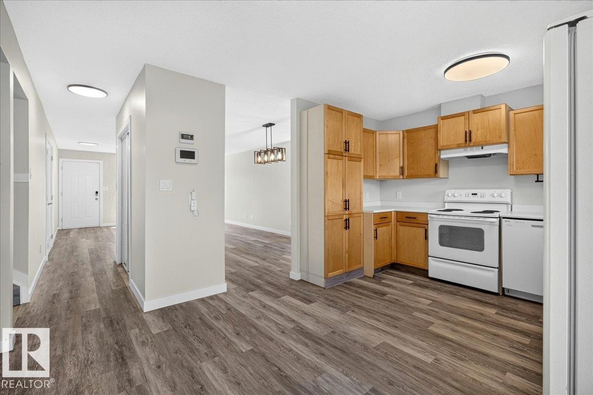 Kitchen featuring wood cabinetry, white appliances, and light countertops - 4212 32 Avenue Nw, Edmonton, AB - Indoor Photo Showing Kitchen