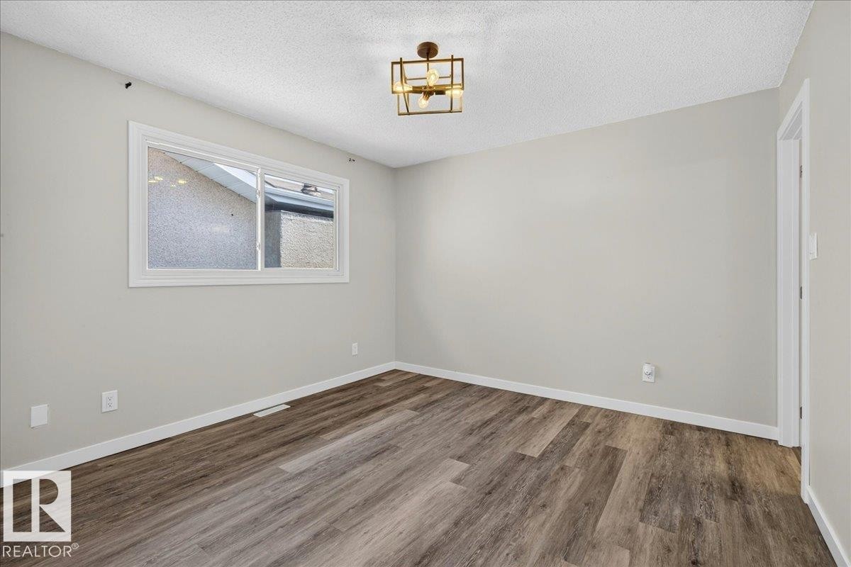 Room featuring wood-finish flooring, light gray wall paint, and white baseboards - 4212 32 Avenue Nw, Edmonton, AB - Indoor Photo Showing Other Room
