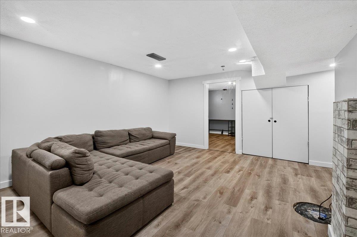 Spacious interior room featuring wood-finish flooring, recessed ceiling lighting, and a white brick-style column - 4212 32 Avenue Nw, Edmonton, AB - Indoor