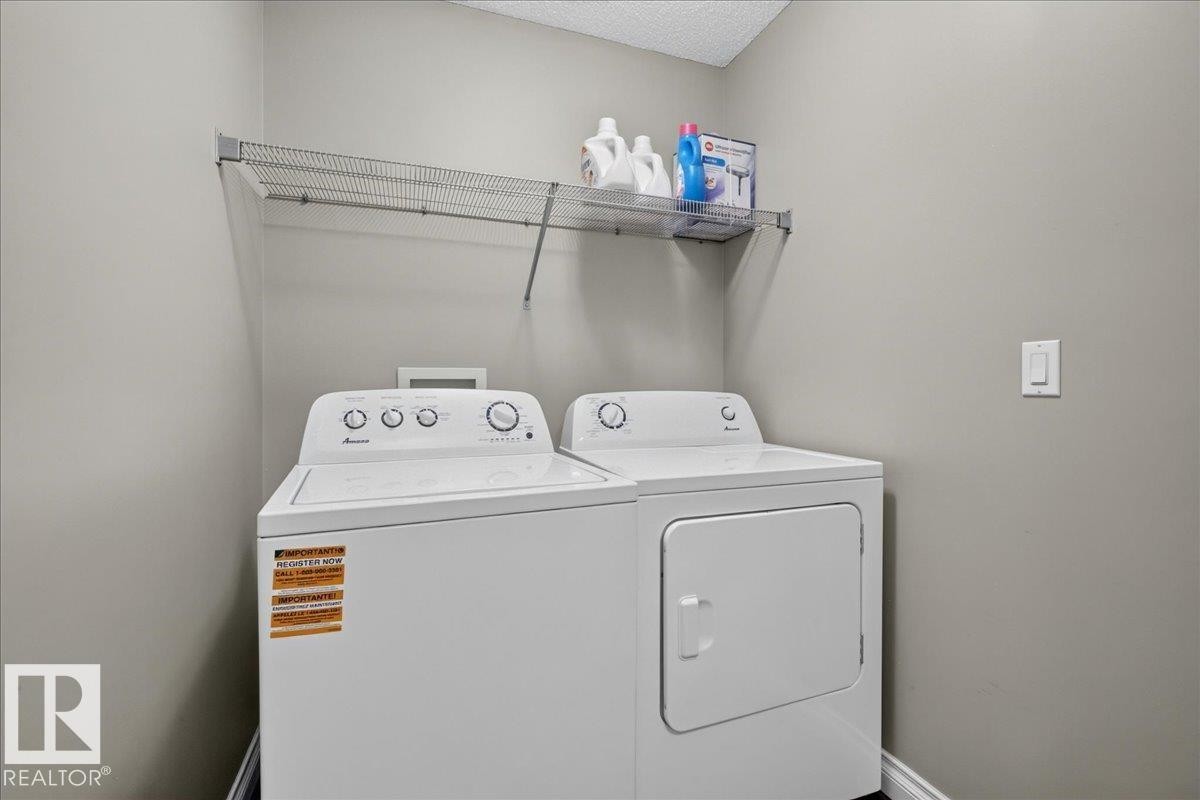 Dedicated laundry area featuring a white top-load washing machine and front-load dryer - 5110 168A Avenue Nw, Edmonton, AB - Indoor Photo Showing Laundry Room
