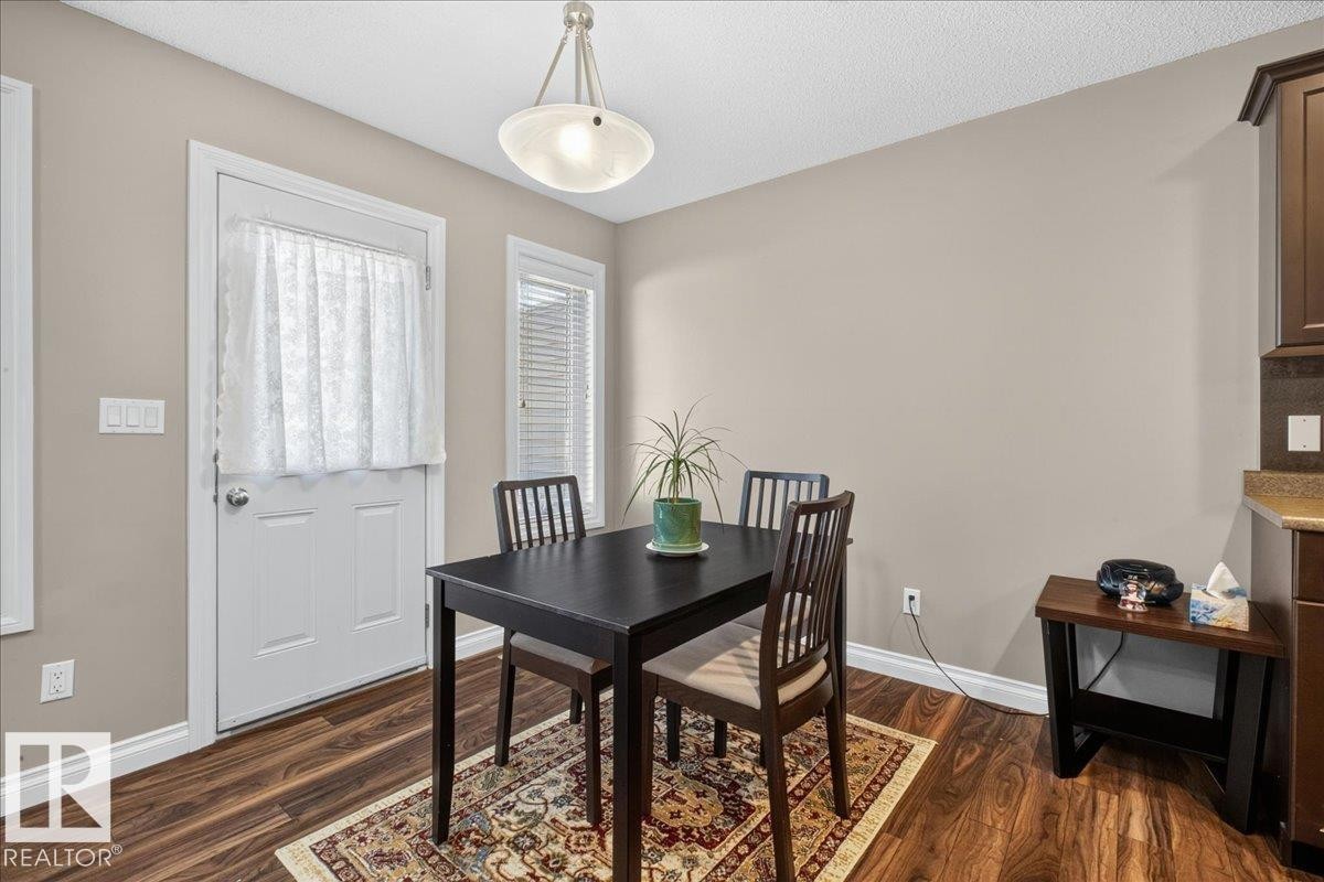 Dining area featuring wood-finish flooring, neutral wall tones, and a built-in pendant light fixture - 5110 168A Avenue Nw, Edmonton, AB - Indoor Photo Showing Dining Room