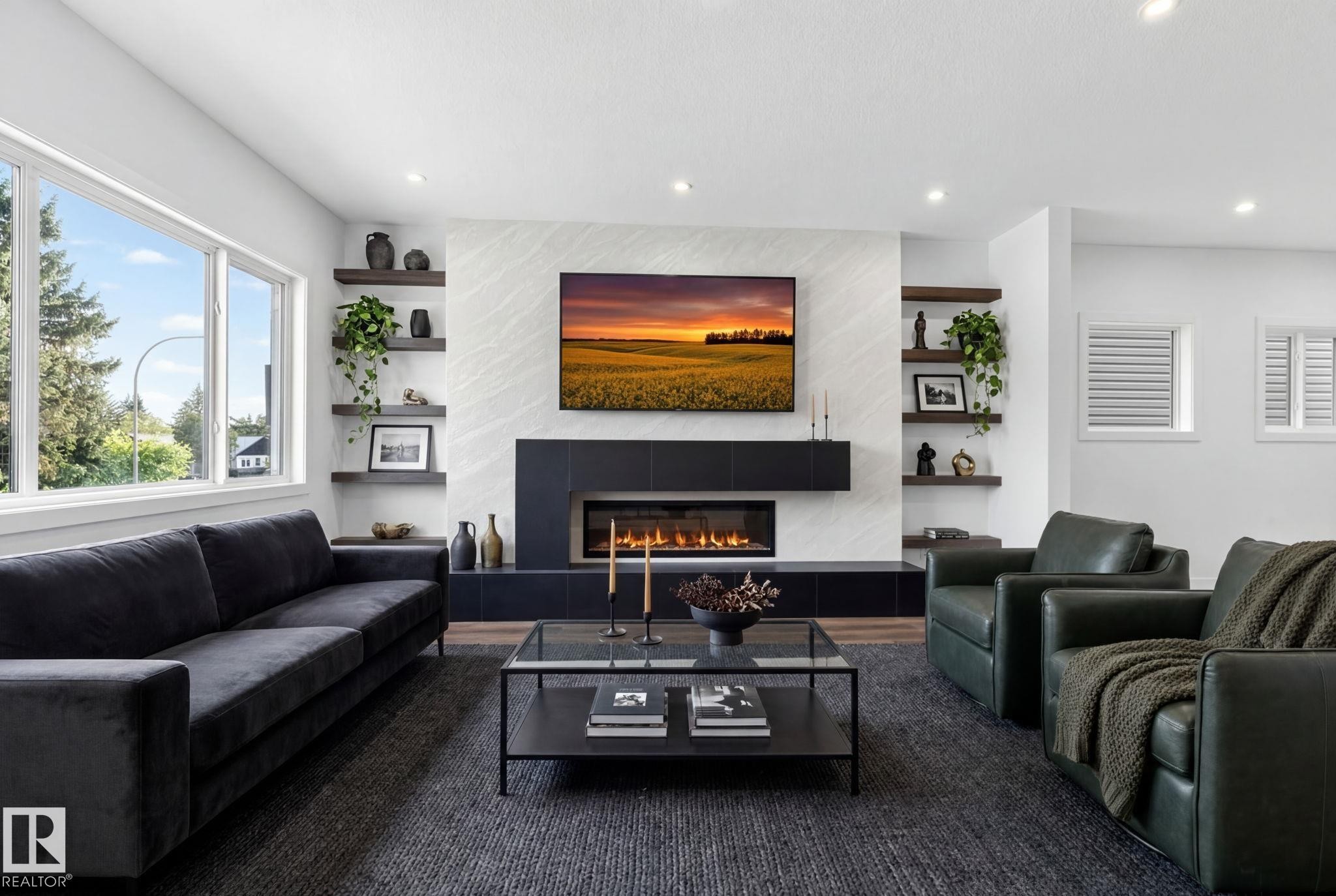 Living space featuring a linear fireplace with a black surround, flanked by built-in wood shelving and large windows - 5308 103A Avenue, Edmonton, AB - Indoor Photo Showing Living Room With Fireplace