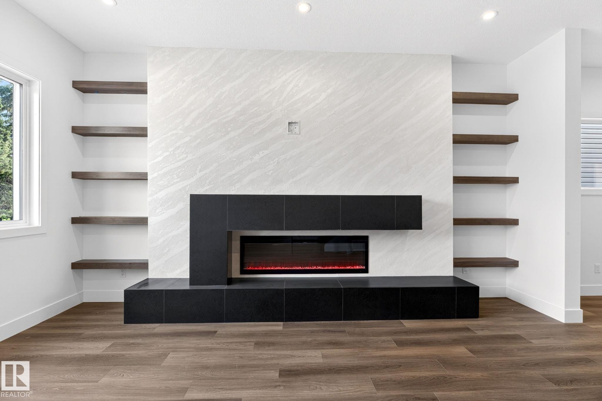 Feature wall with a modern linear fireplace, flanked by built-in wood-finish shelving - 5308 103A Avenue, Edmonton, AB - Indoor With Fireplace