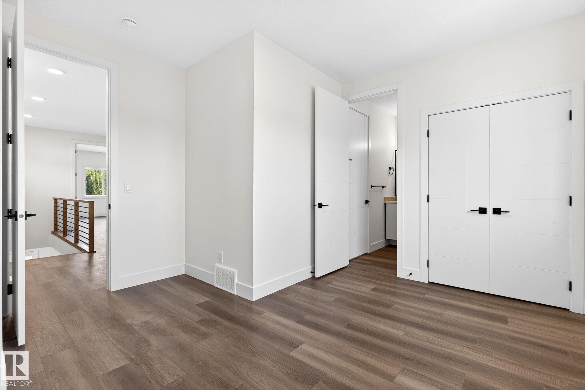 Wood-finish flooring throughout, complemented by white trim and neutral wall tones - 5308 103A Avenue, Edmonton, AB - Indoor Photo Showing Other Room