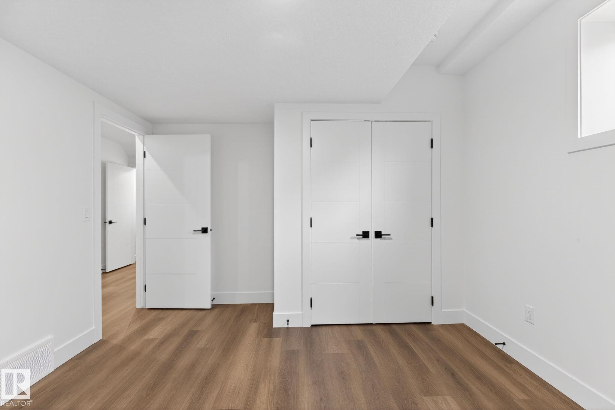 Bright room featuring wood-finish flooring, white walls, and white trim - 5308 103A Avenue, Edmonton, AB - Indoor Photo Showing Other Room