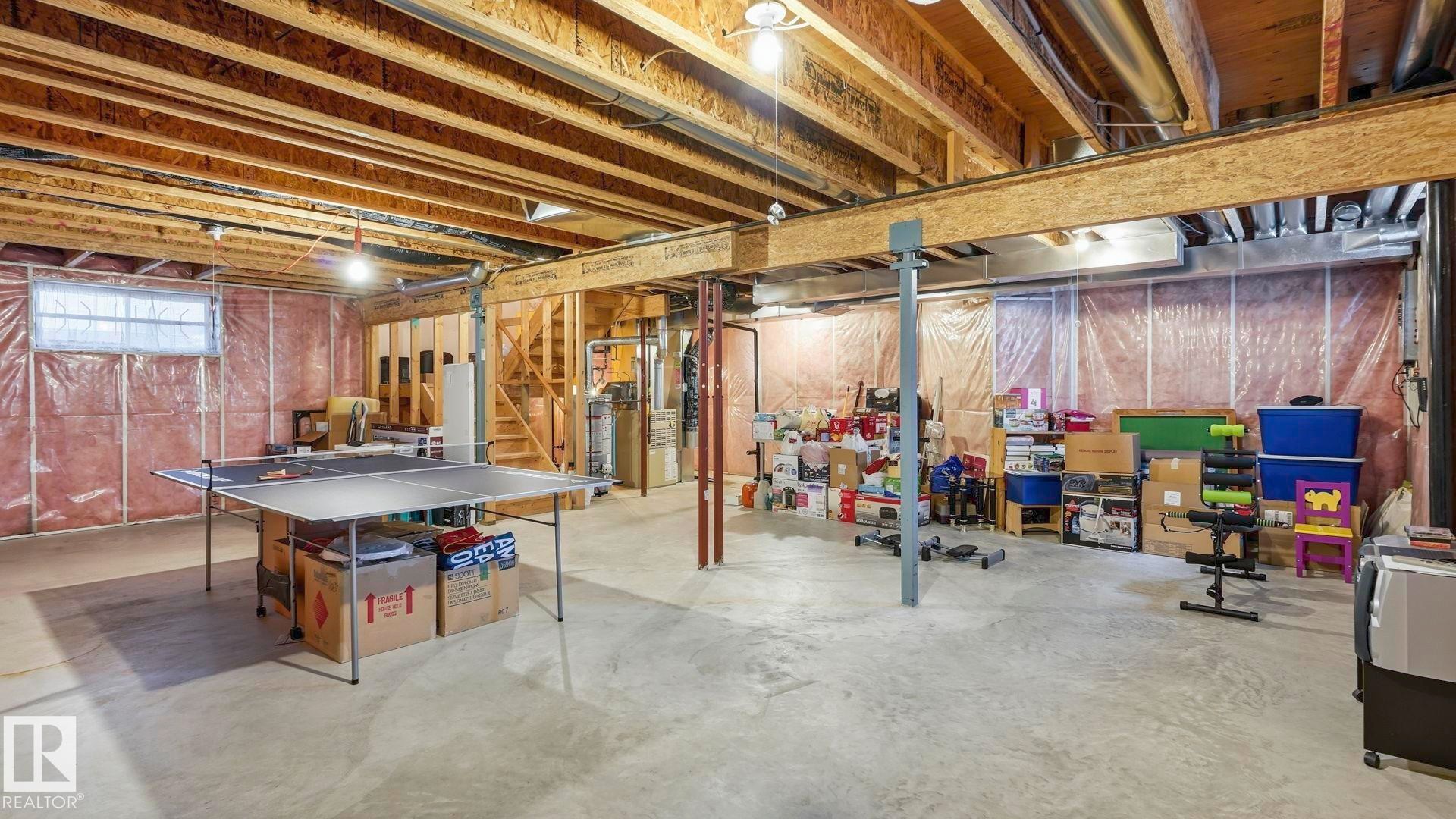 Expansive unfinished basement featuring exposed wood joists, concrete flooring, and partial framing with insulation - 125 Dechene Road Nw, Edmonton, AB - Indoor Photo Showing Basement