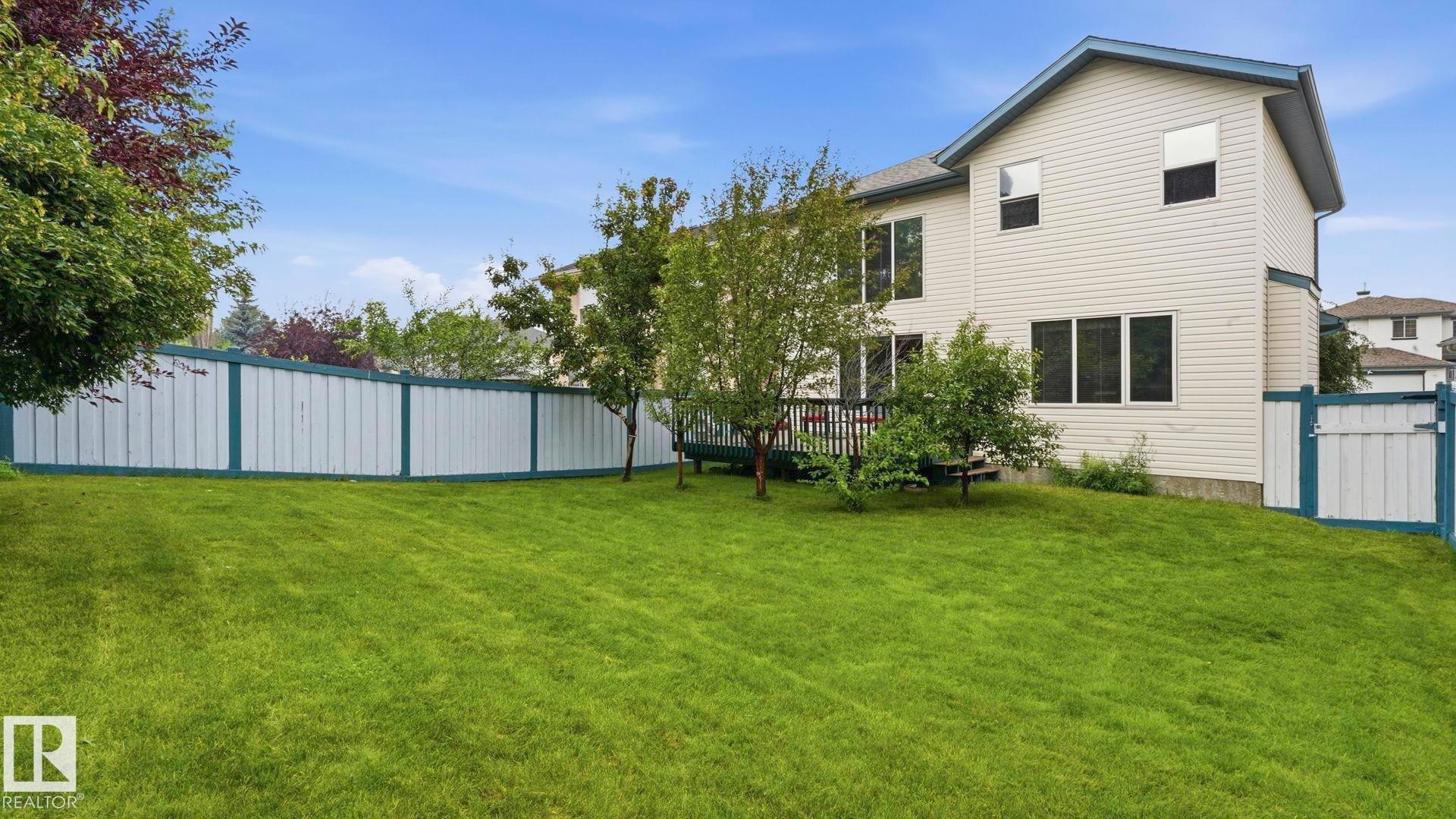 Expansive green lawn with a white privacy fence - 125 Dechene Road Nw, Edmonton, AB - Outdoor