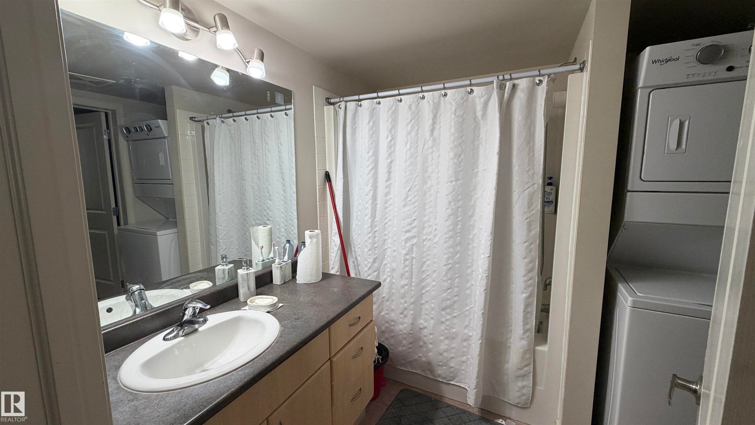 Bathroom featuring a vanity with an oval sink, chrome faucet, and dark-finish countertop - #2401 10180 104 St Nw, Edmonton, AB - Indoor Photo Showing Bathroom