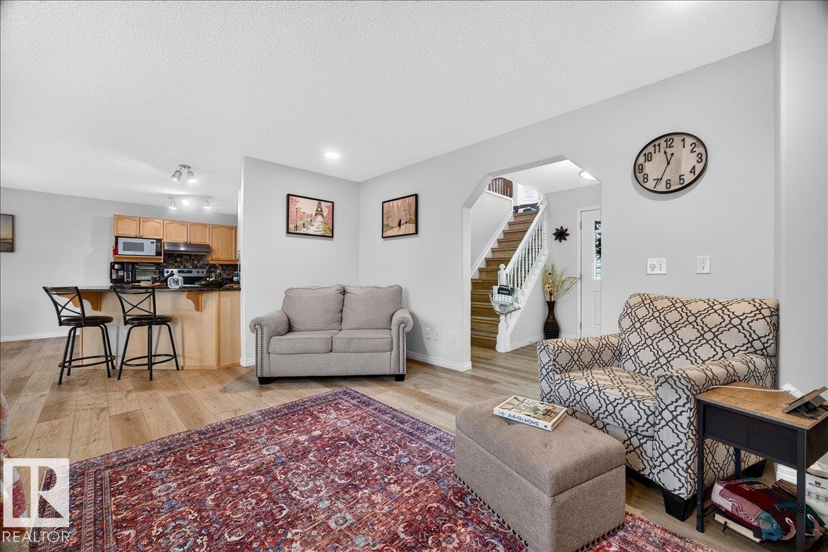 Open-concept living area featuring wood-finish flooring, light grey wall paint, and recessed lighting - 6 Norfolk Close, St. Albert, AB - Indoor Photo Showing Living Room