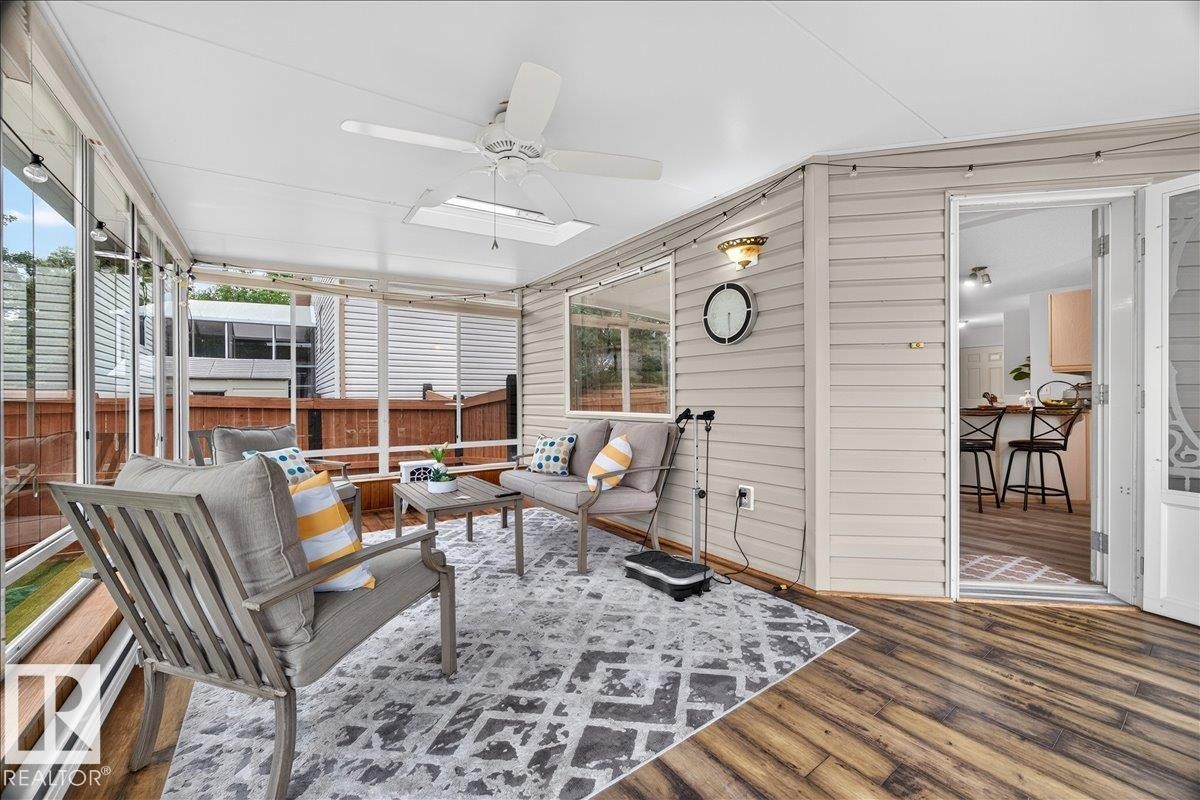Screened porch featuring wood-finish flooring, white siding, and a ceiling fan - 6 Norfolk Close, St. Albert, AB - Outdoor With Exterior