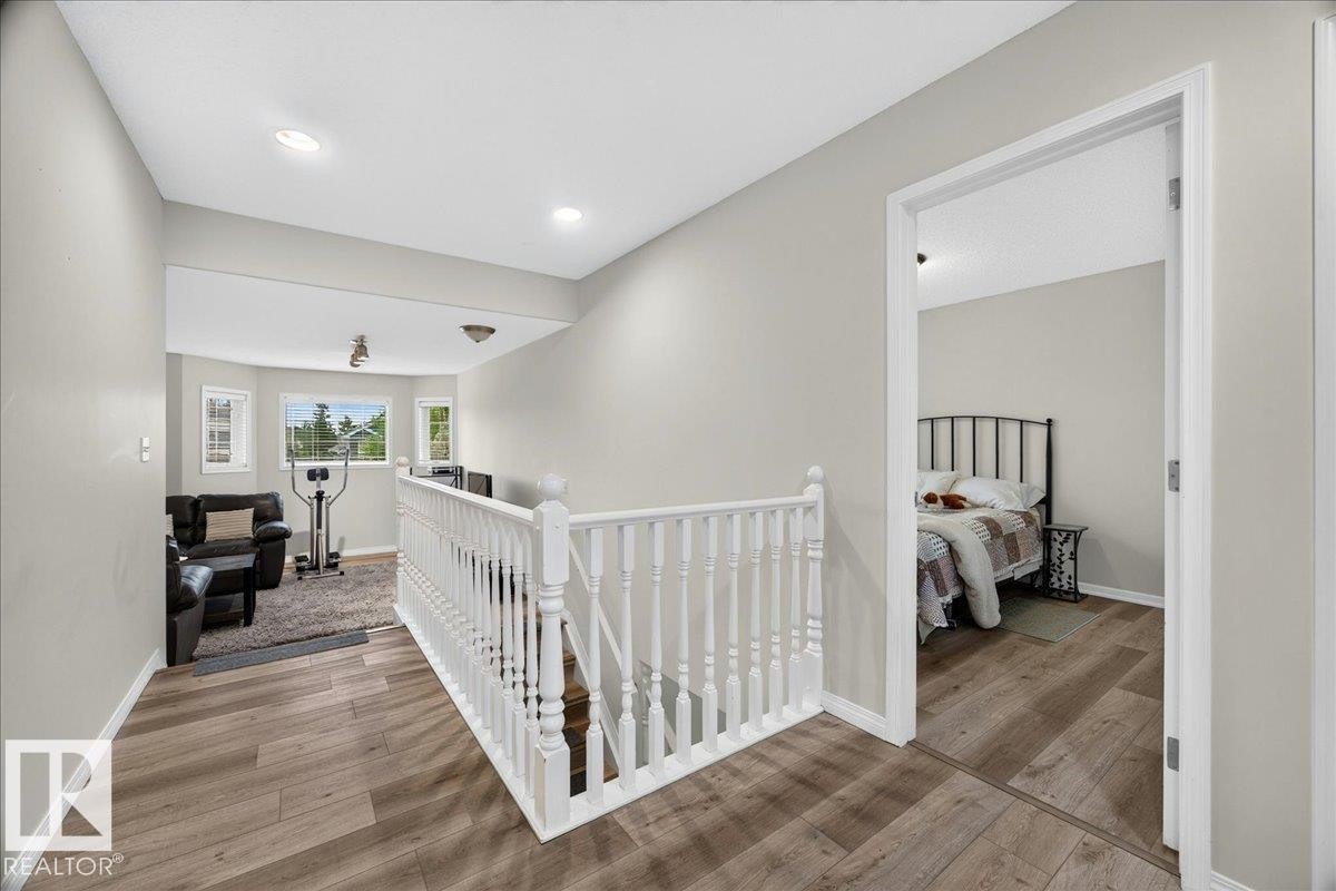 Upper-level landing featuring wood-finish flooring, white spindle railing, and recessed lighting - 6 Norfolk Close, St. Albert, AB - Indoor Photo Showing Other Room