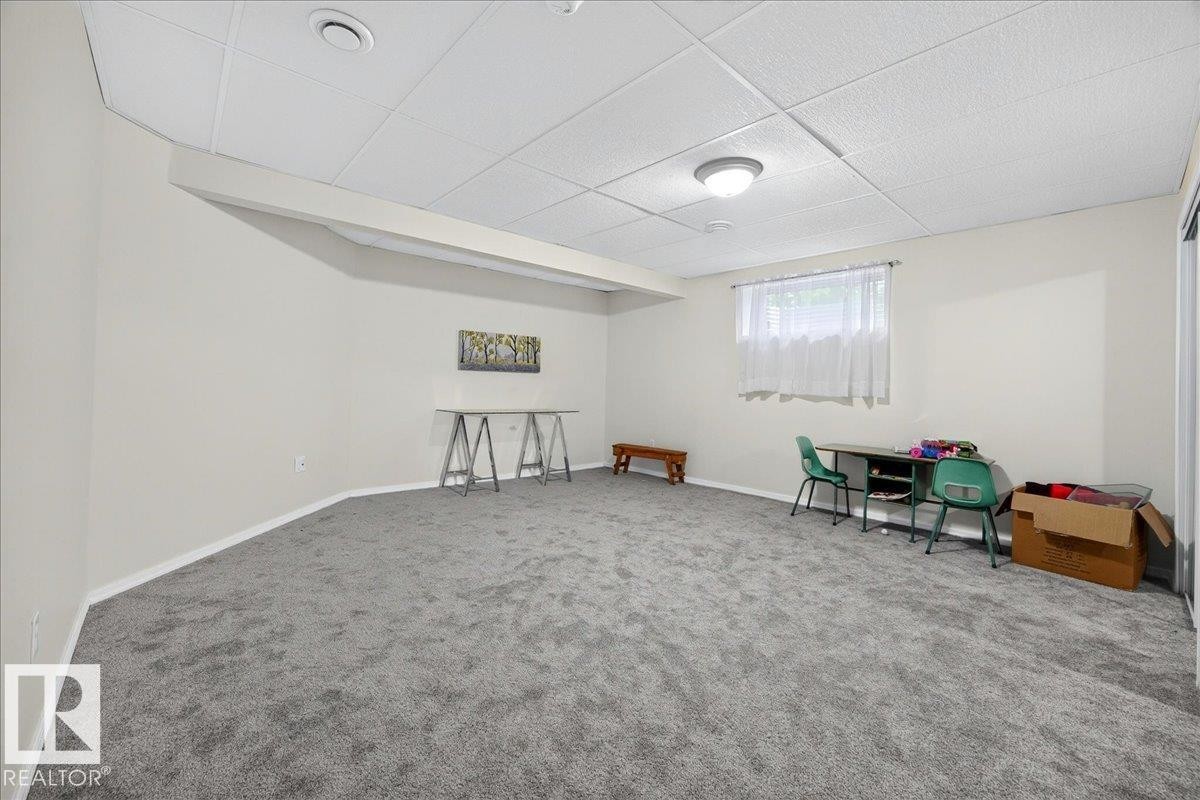 Spacious room featuring light gray carpeting, neutral painted walls, and a drop ceiling with recessed lighting - 6 Norfolk Close, St. Albert, AB - Indoor