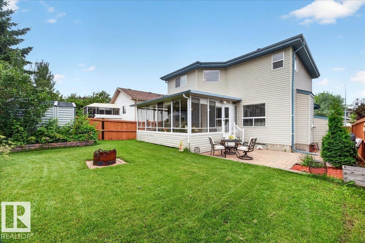 Expansive backyard featuring a green lawn, a brick paver patio, and a screened-in sunroom - 6 Norfolk Close, St. Albert, AB - Outdoor