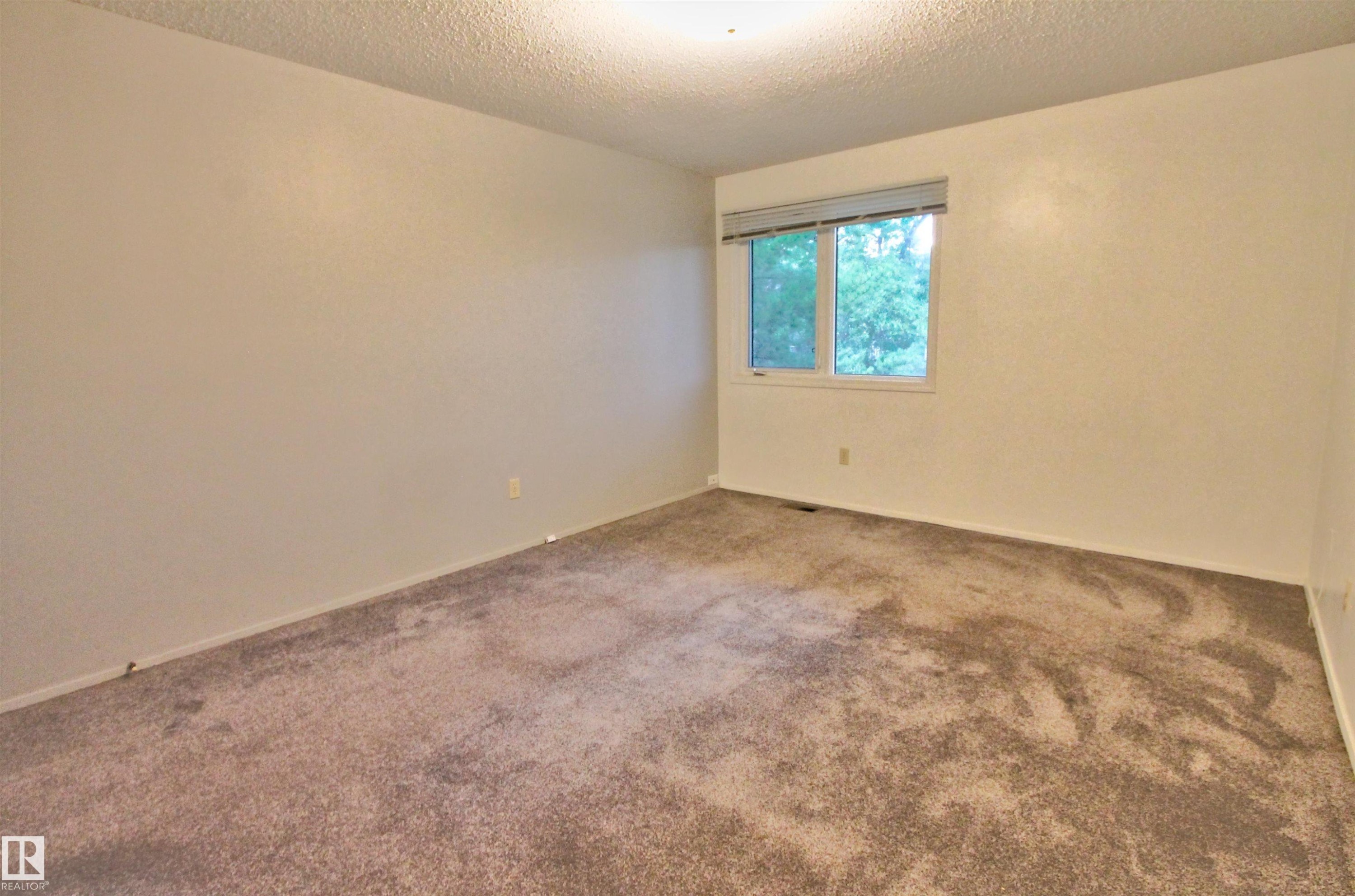 Neutral-toned carpeted room with light-colored walls, featuring a window with a blind - #302 47 Akins Dr, St. Albert, AB - Indoor Photo Showing Other Room