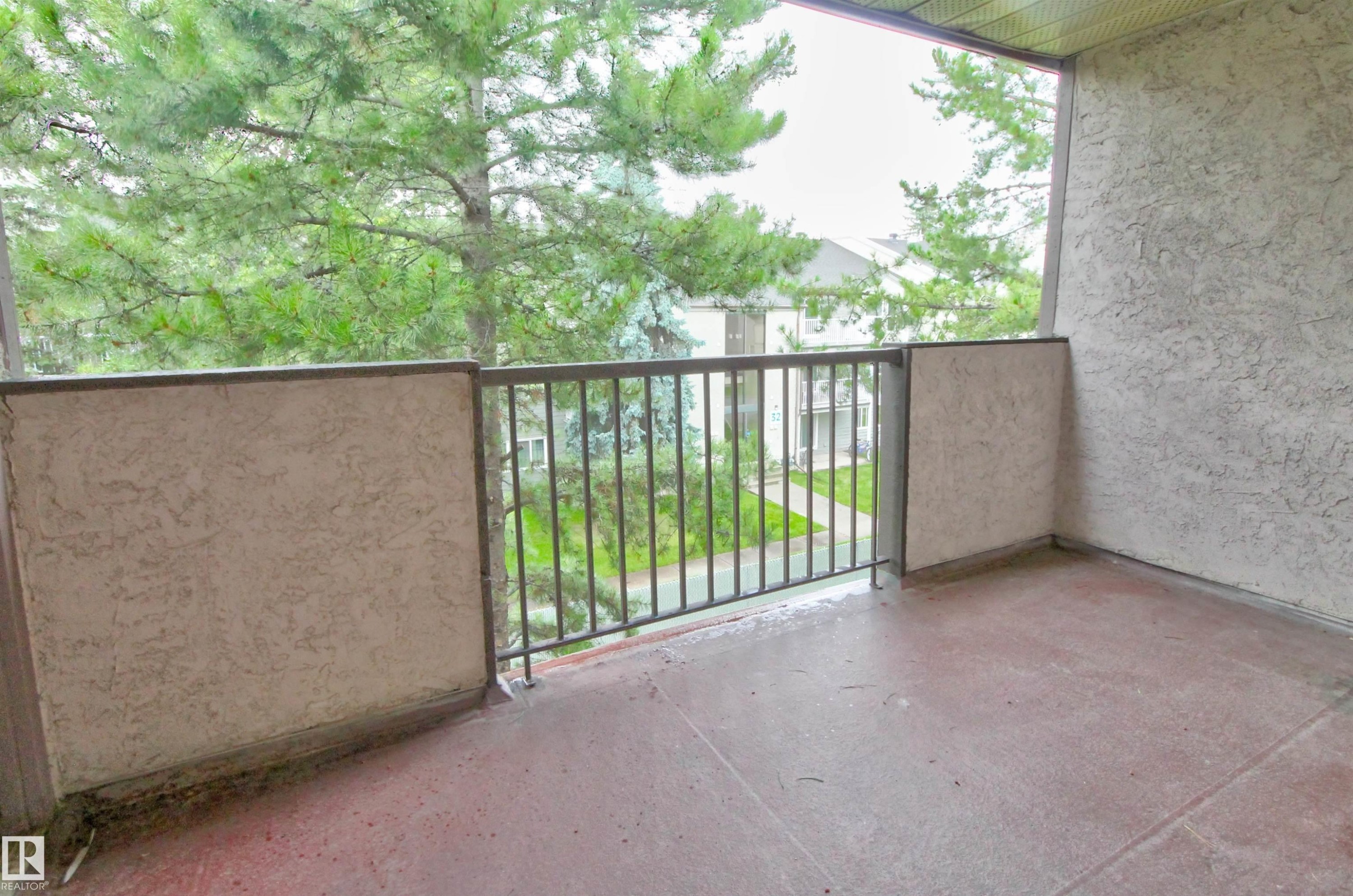 Private balcony with a textured concrete floor, stucco walls, and a metal railing - #302 47 Akins Dr, St. Albert, AB - Outdoor