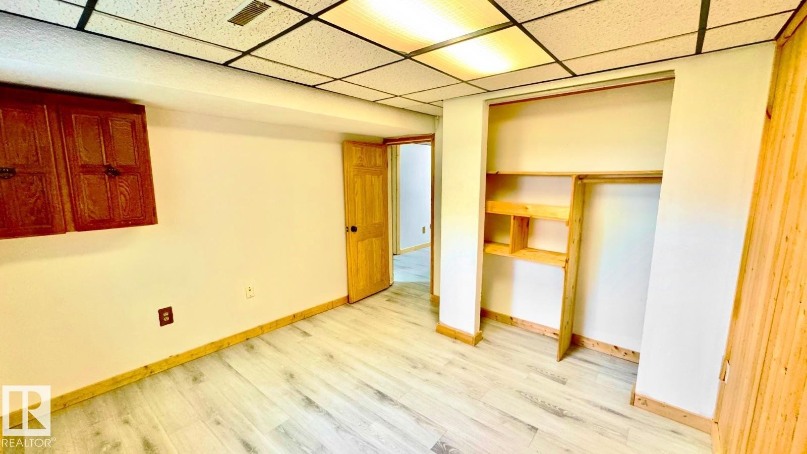 Room featuring light wood-finish flooring, white walls, and wood trim - 5144 37 Avenue Nw, Edmonton, AB - Indoor Photo Showing Other Room
