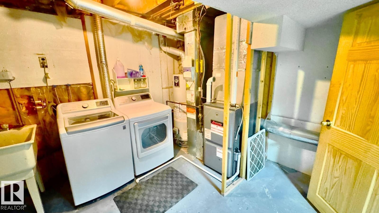 Utility area featuring a laundry sink, exposed ductwork, furnace, and a water heater - 5144 37 Avenue Nw, Edmonton, AB - Indoor Photo Showing Laundry Room