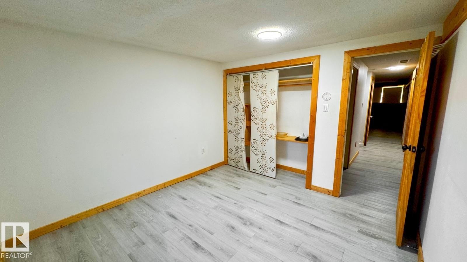 Room featuring wood-finish flooring, white walls, and a flush-mount ceiling light - 5144 37 Avenue Nw, Edmonton, AB - Indoor Photo Showing Other Room